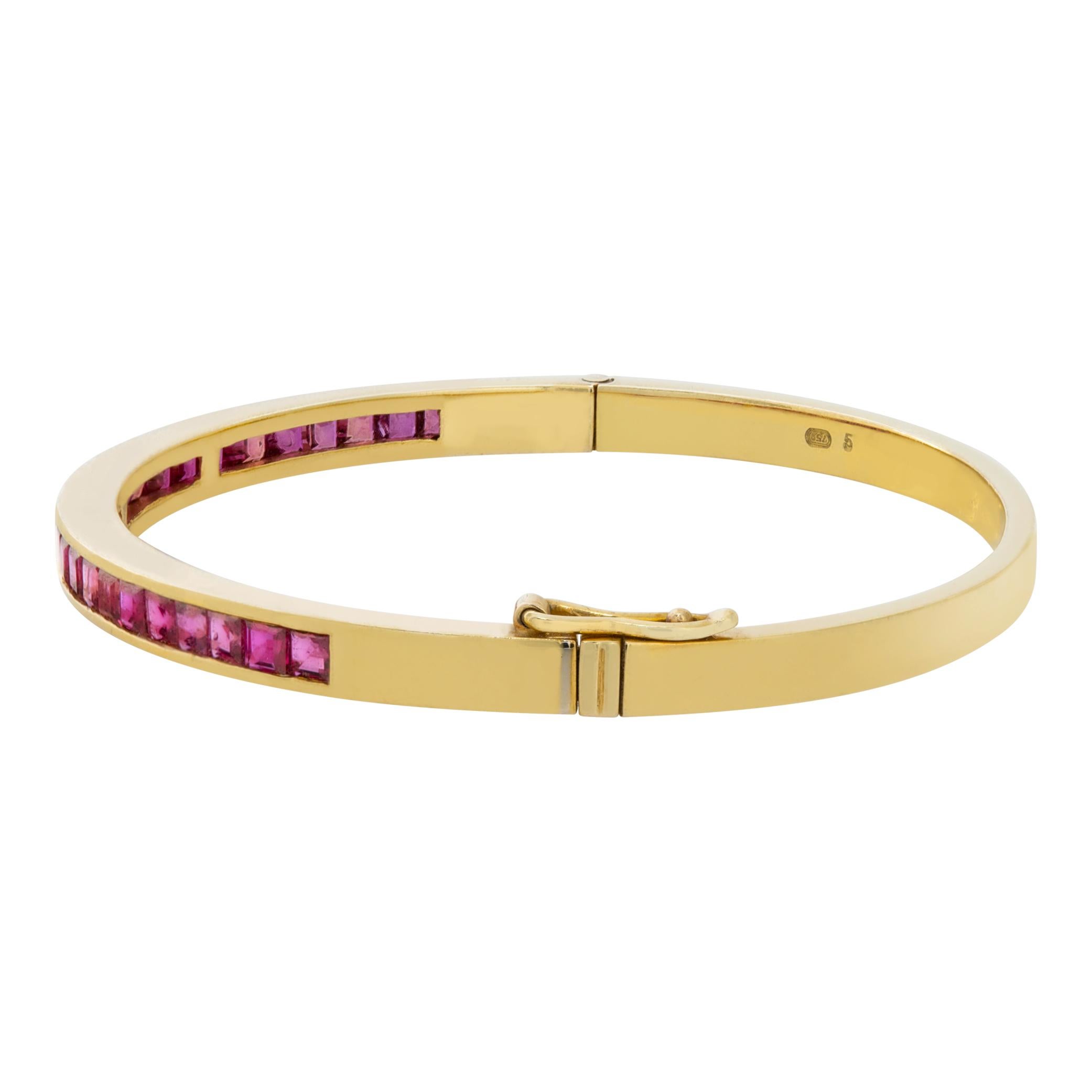 Sleek 18k yellow gold bangle with 1 carat in channel set square cut rubies. Fit for wrists up to 7.5 inches, has safety on clasp.