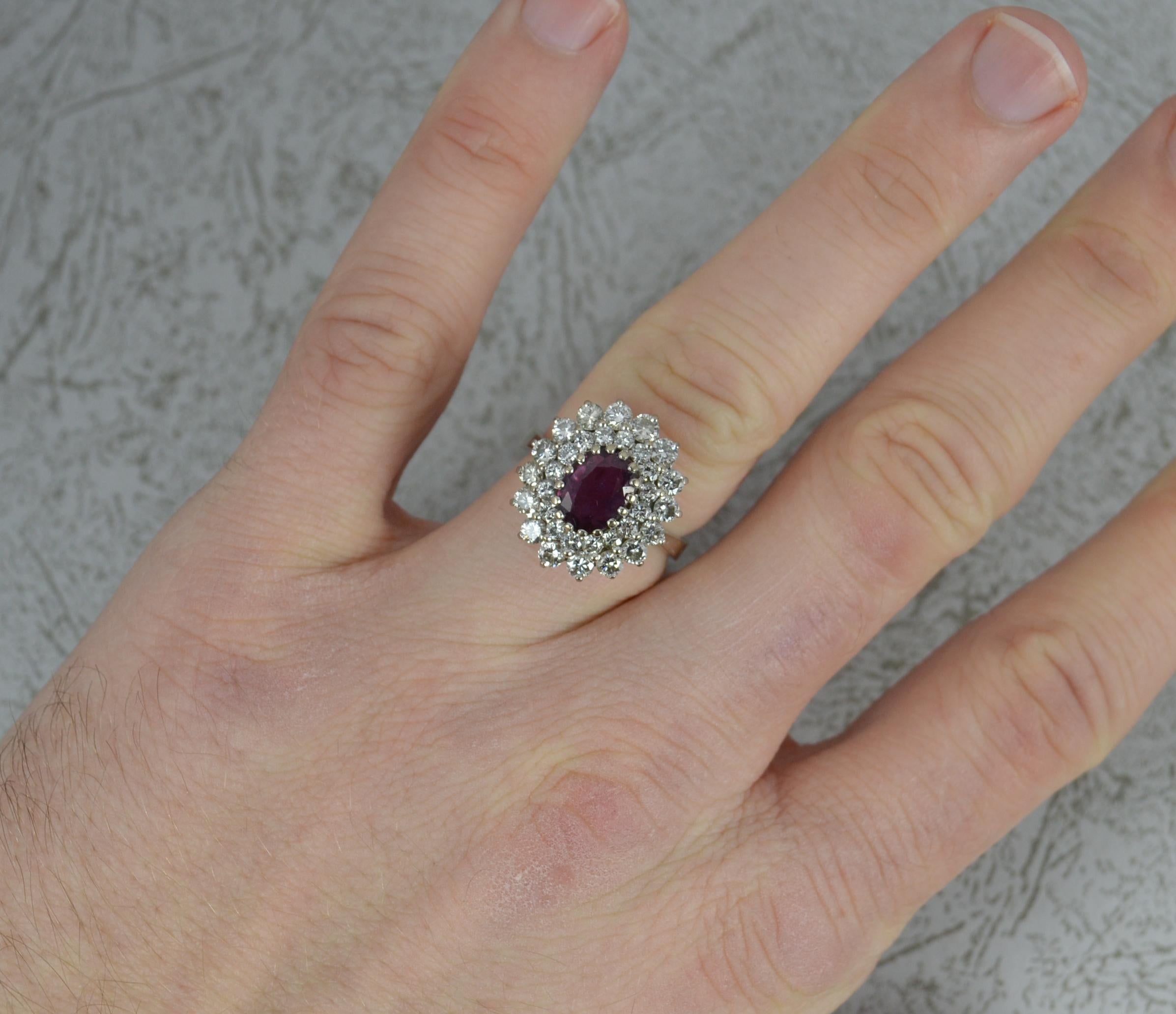 A stunning ladies cluster ring.
18 carat white gold example.
Designed with a good quality oval cut ruby to centre in multi claw setting. 5.9mm x 8.1mm approx. Surrounding are two tiers of sixteen natural, round brilliant cut diamonds. Vs1 clarity,