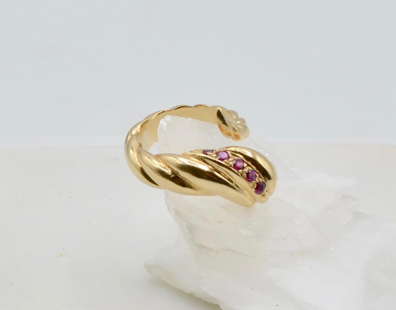 This modern version of the snake ring has a twisted groove design with 5 round rubies  (aprox. 0.24 TCW) set to mimic a head with red eyes. The ring has a nice weight to it and would look stunning alone or with other rings. It is a size 6 3/4 and