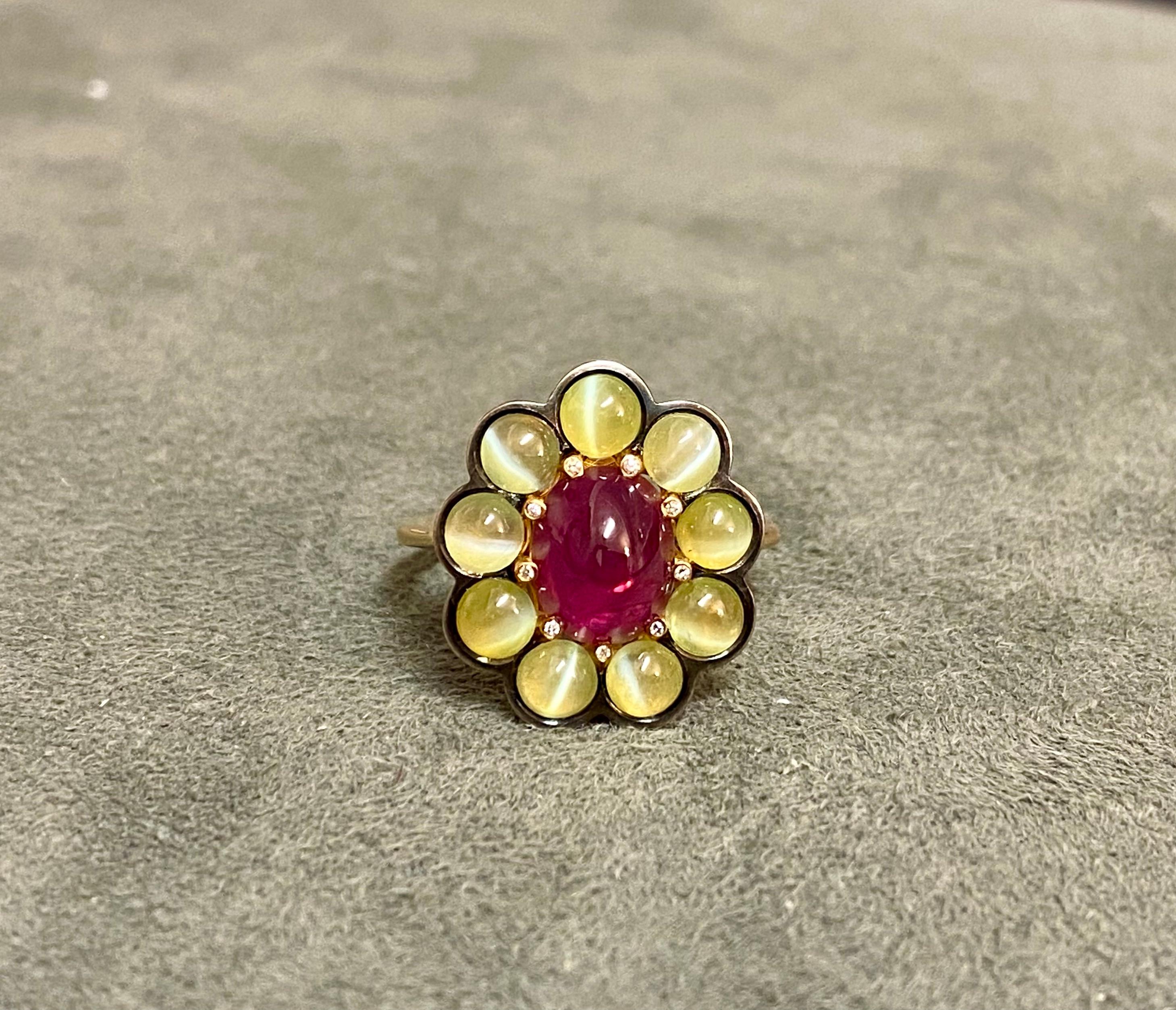 A 2.38ct Ruby set with 9 Cat's Eye Chrysoberyls (3.01ct) in 18k yellow and blackened gold. The 9 claws holding the ruby are set with 9 diamonds. 