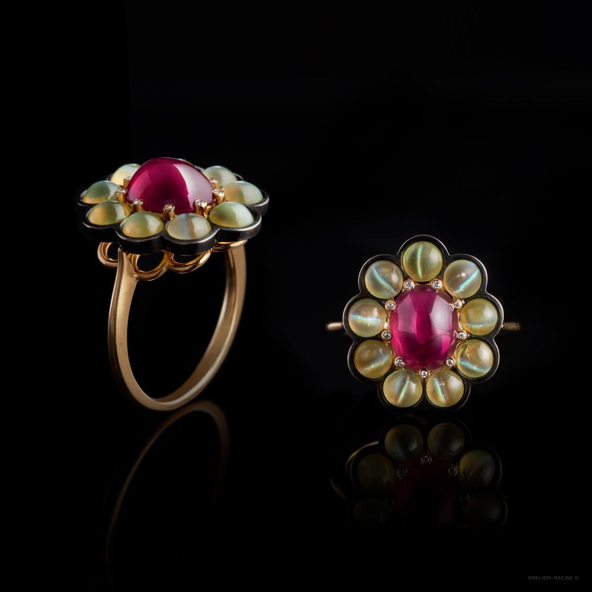 A 2.38ct Ruby set with 9 Cat's Eye Chrysoberyls (3.01ct) in 18k yellow and blackened gold. The 9 claws holding the ruby are set with 9 diamonds. 