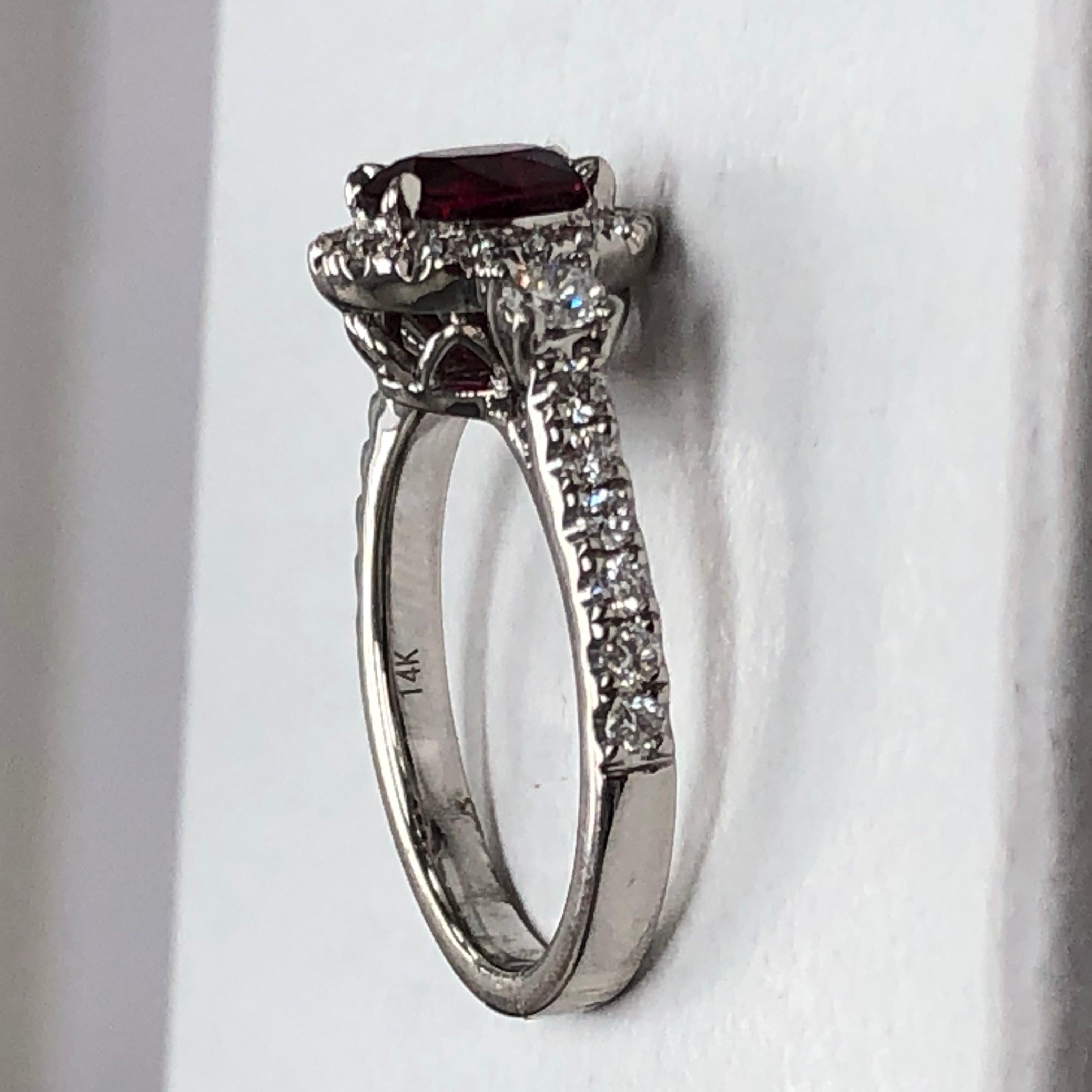 This classy and timeless ring features a beautiful and sparkly oval ruby.  The ruby is surrounded by shiny brilliant cut diamonds.  This ring also has beautiful round diamond accents on each side of the halo with round diamonds going down the
