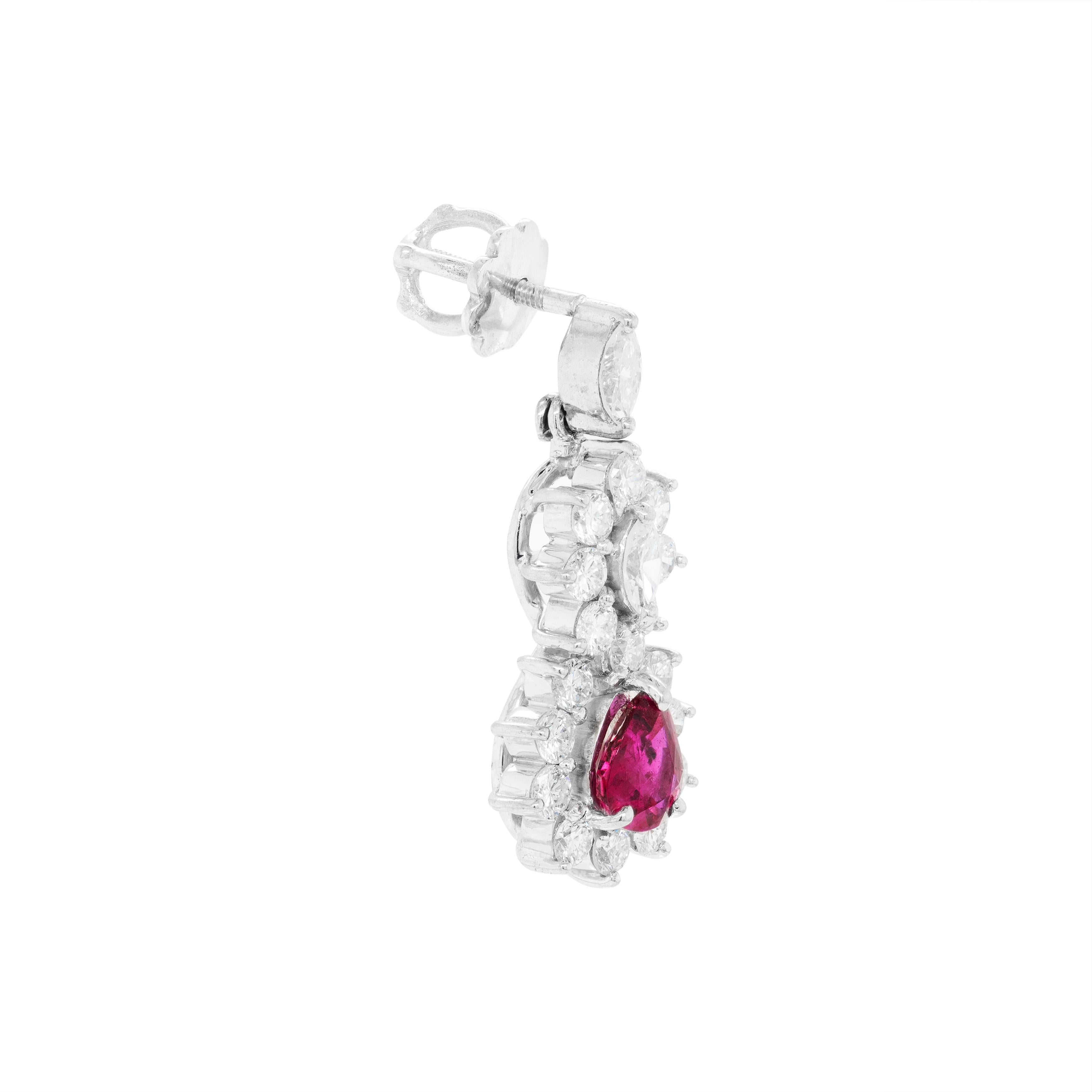 A beautiful pair of cluster earrings featuring a fine quality pear shaped ruby weighing approximately 0.55ct each in a three claw open back setting. The rubies are accompanied by a cluster of claw set marquise shaped diamonds and round brilliant cut