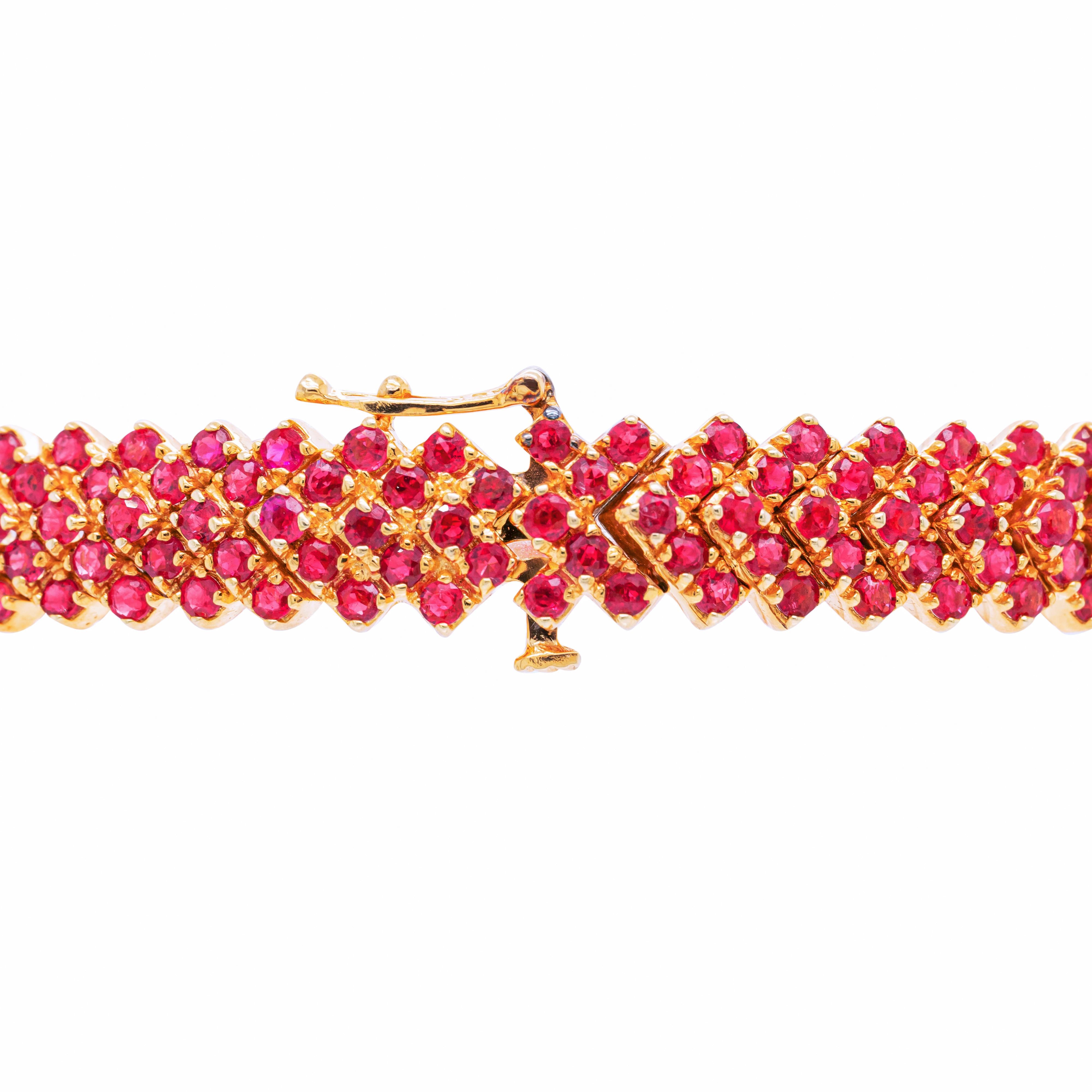 This wonderful bracelet features an impressive 239 round cut rubies, totalling to an approximate weight of 8.00 carats, all mounted in 18 carat yellow gold. The vibrant rubies are set in multiple oblique rows, beautifully interrupted by three rows