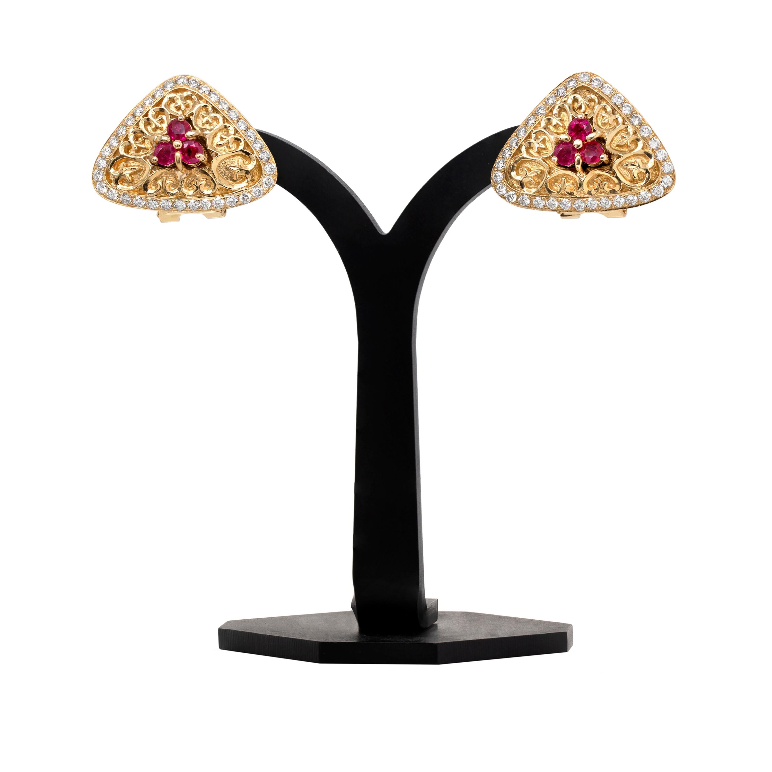 Ces boucles d'oreilles inhabituelles en or jaune 18 carats ont été magnifiquement conçues dans une forme triangulaire avec trois rubis ronds brillants sertis en griffe au centre, pesant un poids total approximatif de 1,00 carat. Les boucles