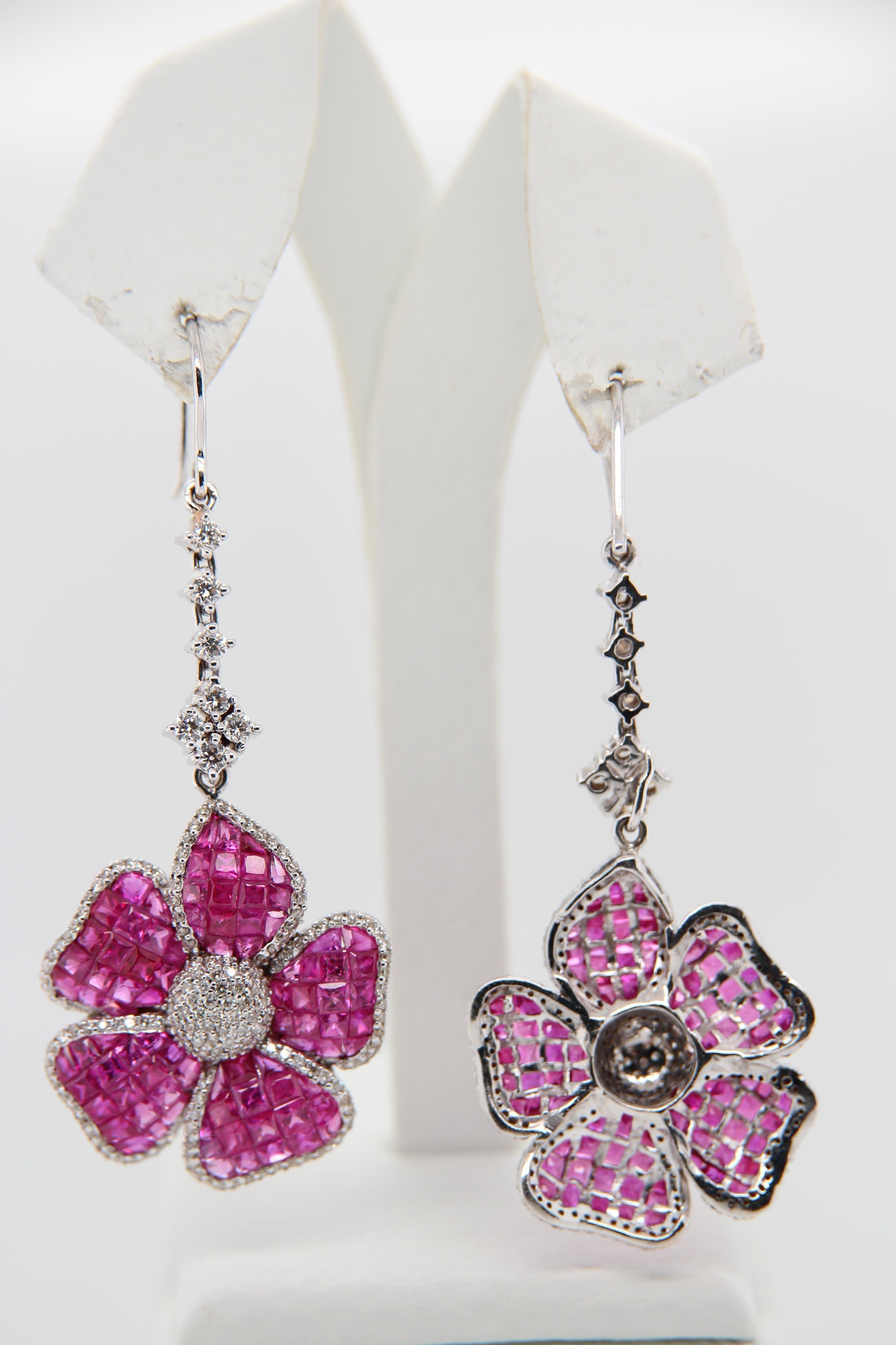 A ruby and diamond earring. The earring is studded with 12.30 carat rubies and 3.37 carat diamonds. It is made in 18 karat white gold 12.90 gross weight.