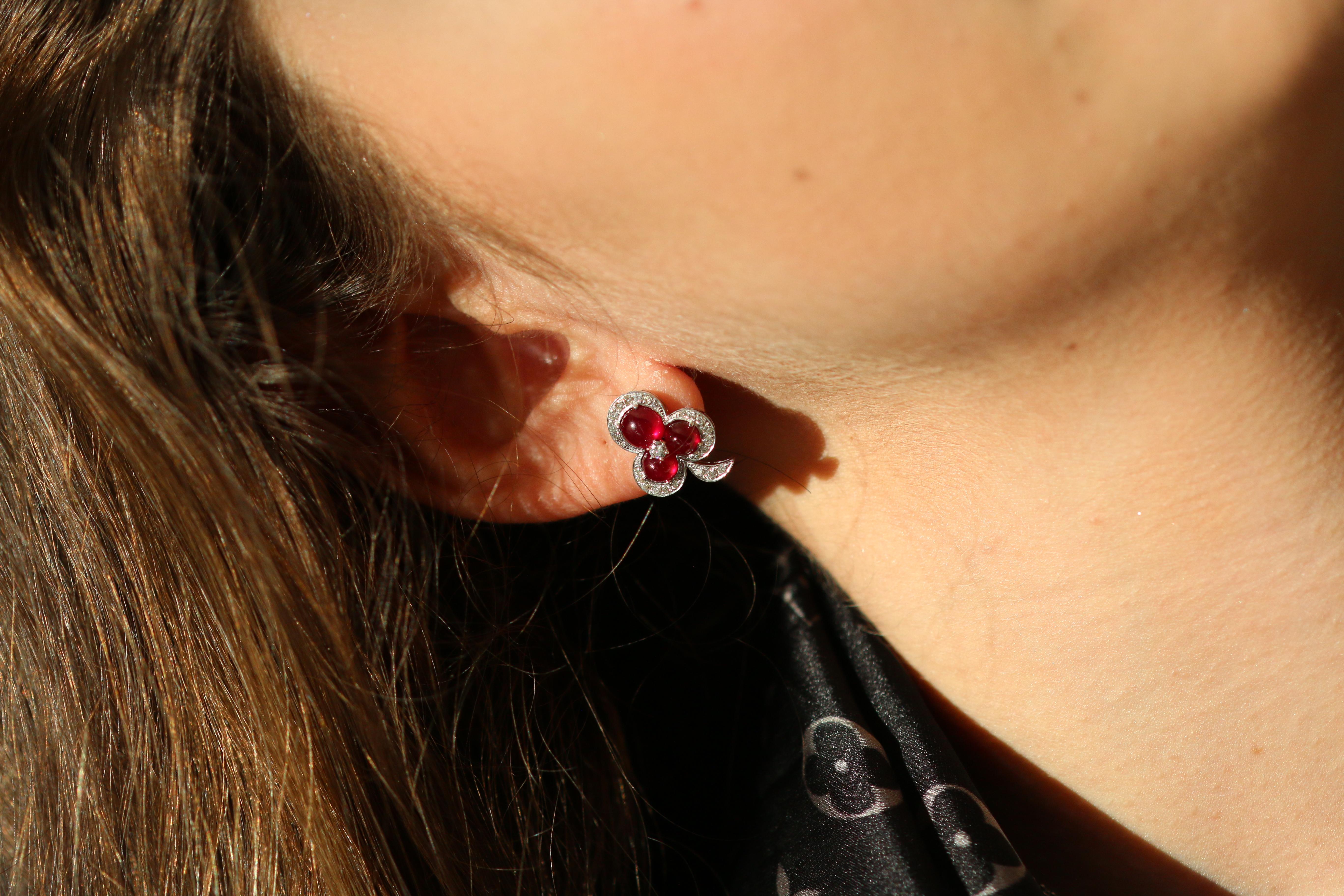 Wonderful ruby and diamond earrings full of delightful colour and delicate design. 

Pools of breathtaking blood red rubies help to create intoxicatingly stunning earrings, shaped as petals within a graceful flower. Bordered by brilliant bright and