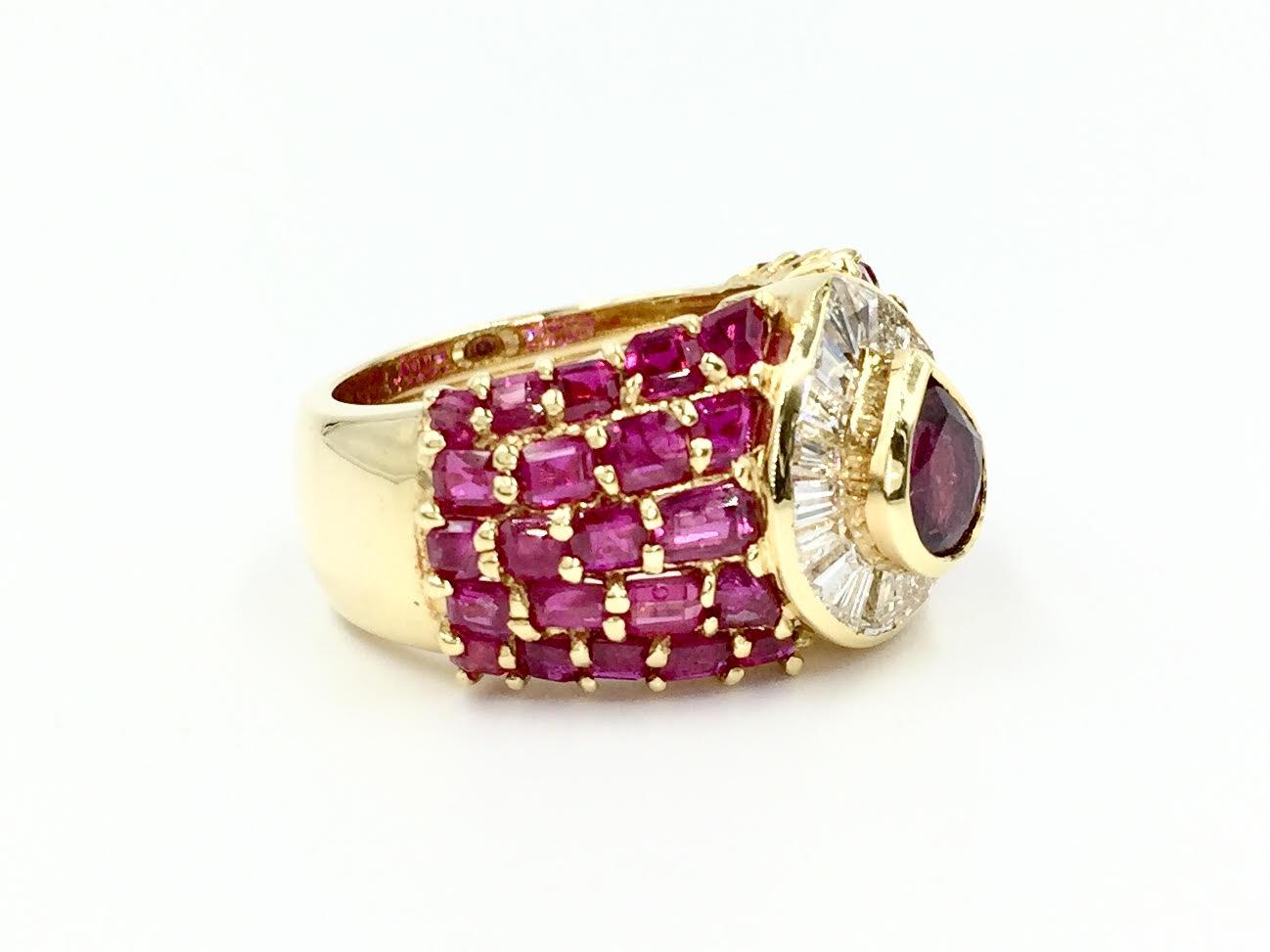Fabulous and fun wide 18 karat yellow gold cocktail ring featuring 7.82 carats of gorgeous rubies with beautiful reddish-pink color and slightly transparent appearance. 0.94 carats of high quality baguette diamonds are perfectly set around a pear
