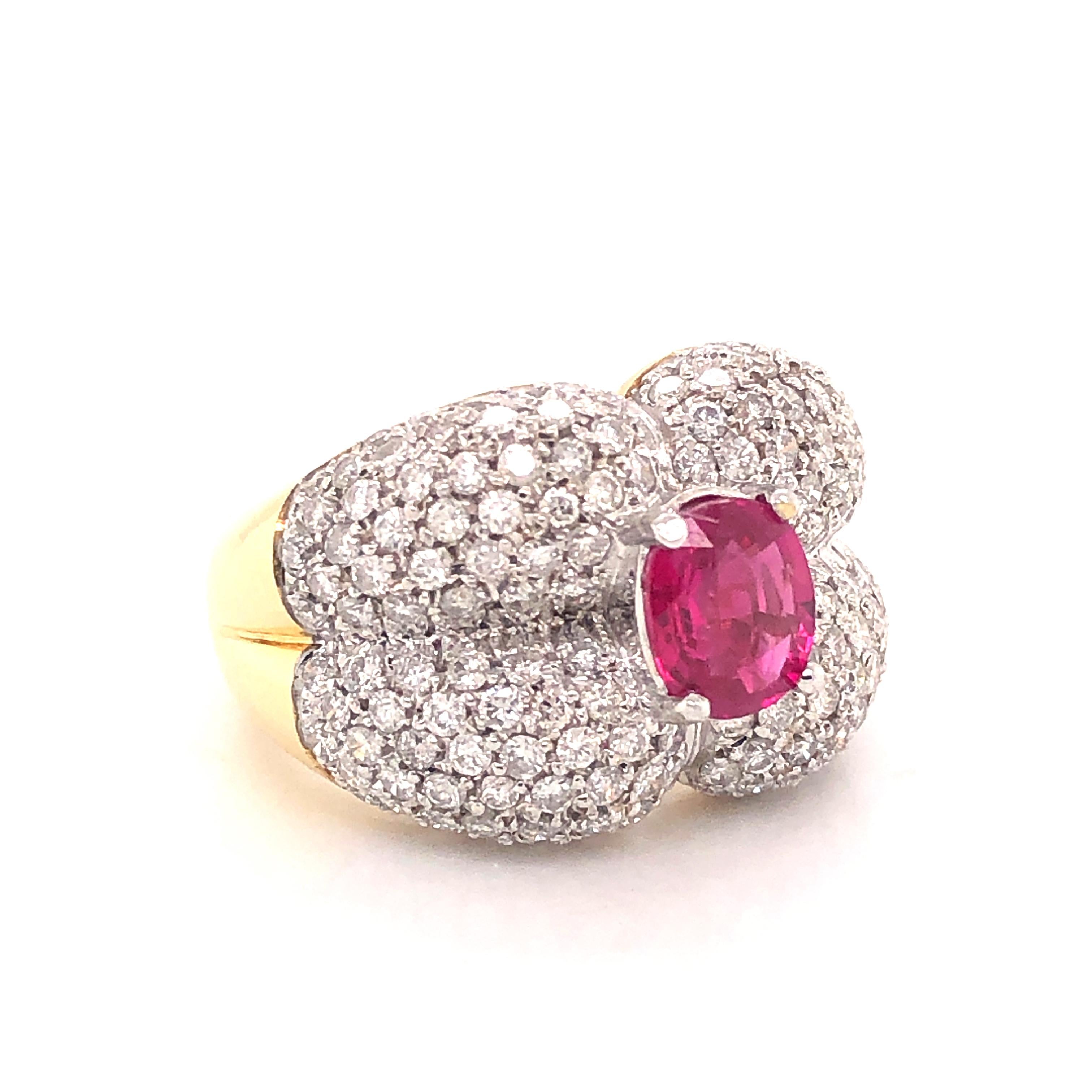 Amazing design on this show stopping Ruby and Diamond ring. Crafted in 18k gold this ring is highlighted with a vibrant red ruby. The ruby gemstone is oval in shape and weighs 1.32 ct.  Surrounding this ruby are all natural round brilliant cut