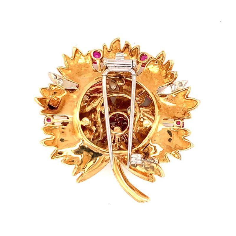 One ruby and diamond 18K yellow gold pendant / brooch featuring a leaf motif design with rubies totaling 3 ct. Enhanced by round brilliant cut diamonds totaling 0.50 ct. Removable brooch measures 45 millimeters in diameter. Attached to an 18K yellow