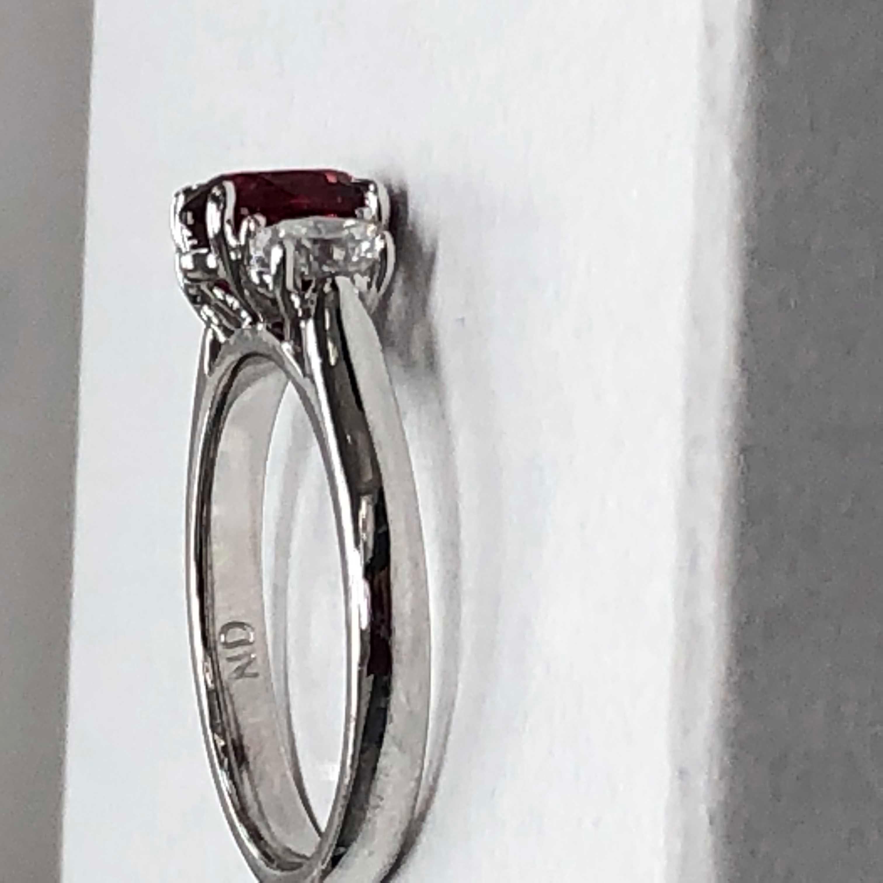 This classy and timeless ring features a beautiful and sparkly oval ruby.  The ruby has an oval diamond set on each side.  The ring has a 14k white gold shank.
Metal:  14k White Gold
Ruby:  1.31ct Oval Ruby
2 Oval Diamonds = .53ctw.  G, VS2