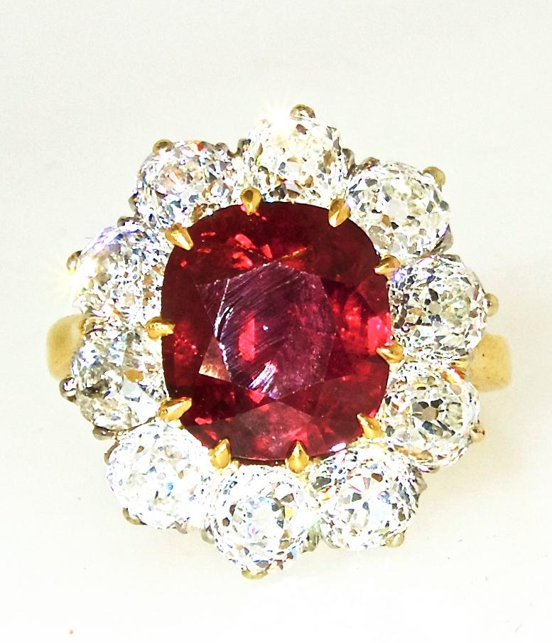 The center ruby weighs approximately 5.25 cts., it is a natural oval ruby displaying a bright pure red color.  It is surrounded by fine mine cut diamonds.  The diamonds weigh approximately 3 cts., and are all H/I and very slightly included.  This