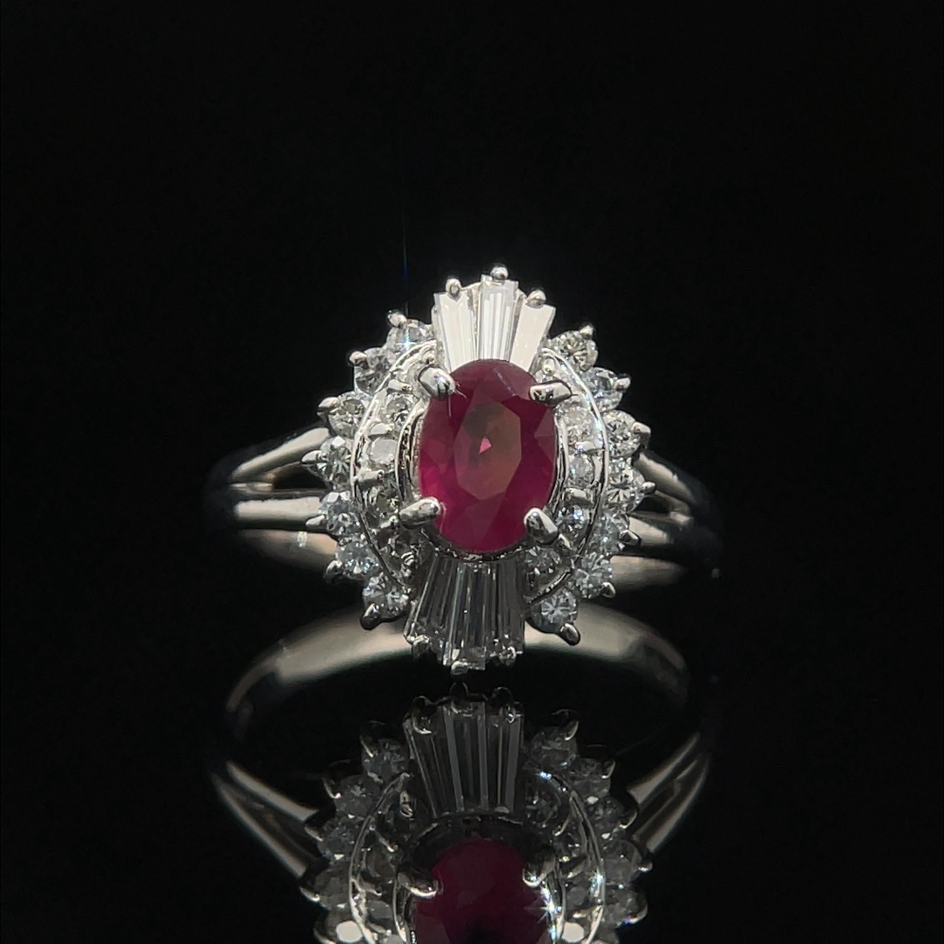 Elevate your elegance with our platinum estate ring, a dazzling showcase of glamour and sophistication. Anchored by a vibrant 0.79ct oval-cut ruby in a secure four-prong setting, the brilliance extends to a halo cluster of baguette and round
