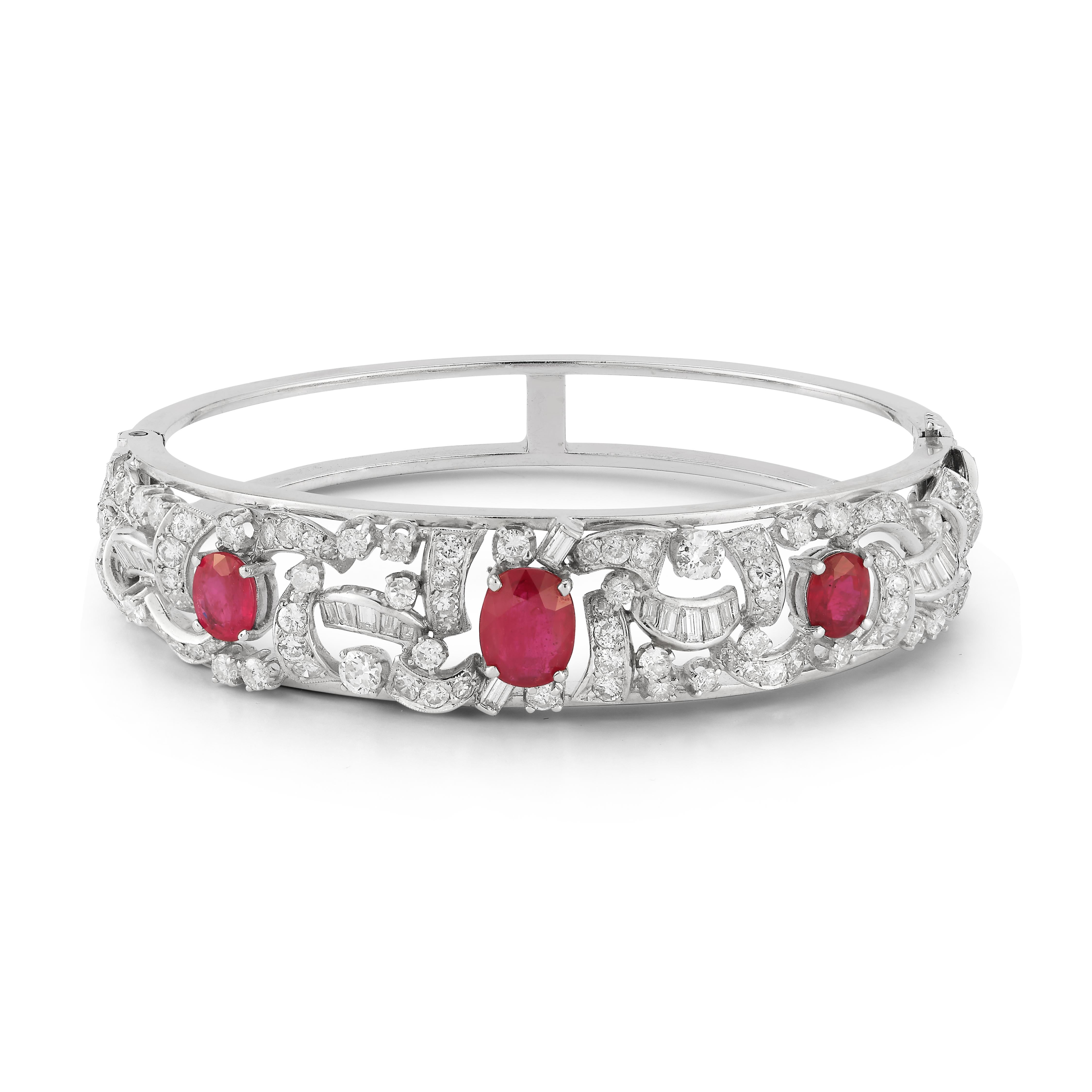  Ruby and Diamond Bangle Bracelet

Description:
A refined and luxurious bangle bracelet crafted in 14K white gold, featuring three mesmerizing oval-cut rubies with a combined weight of approximately 5.26 carats. Each ruby is gracefully framed by a
