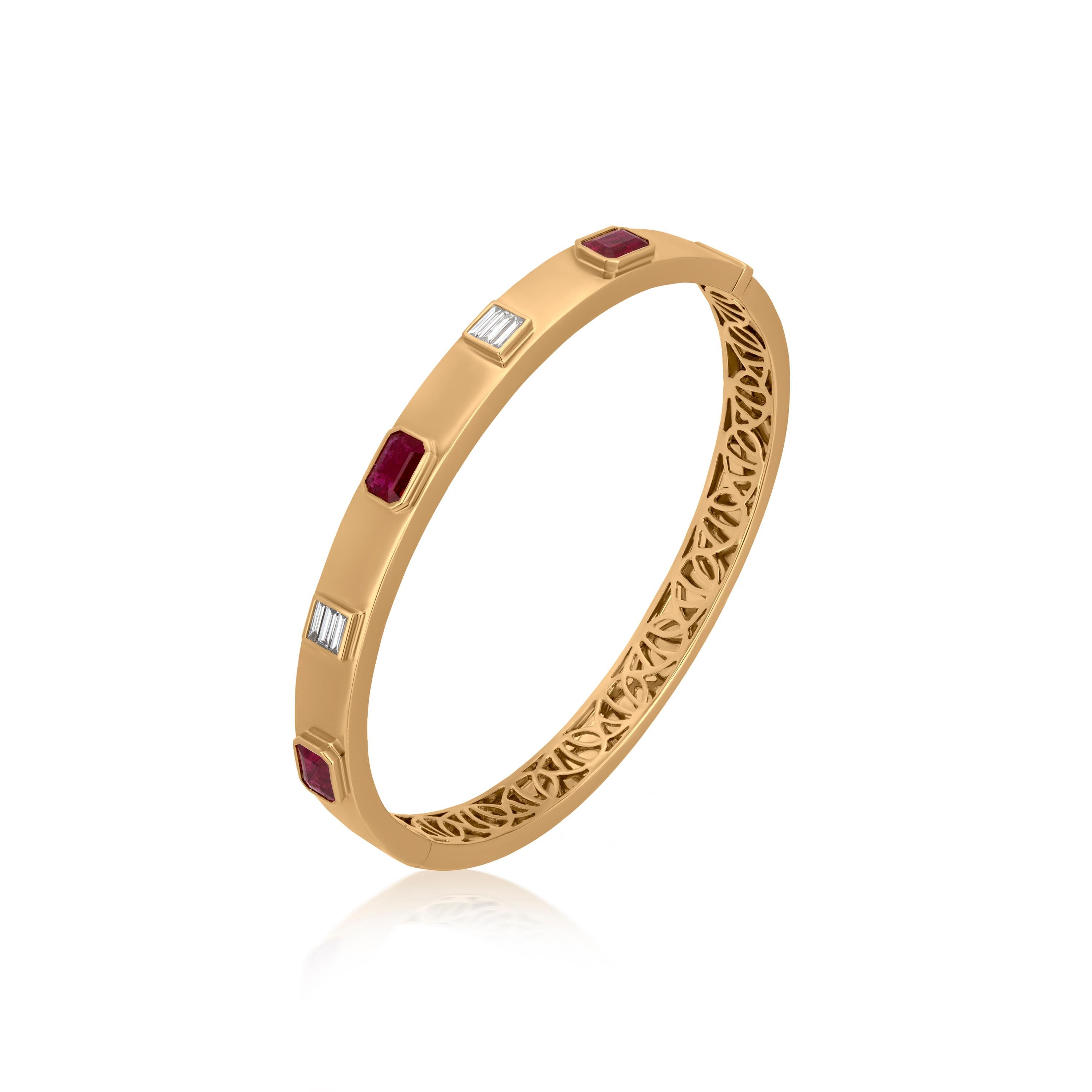 Adorn yourself with this spectacular bangle bracelet. 1.83 ct. t.w. octagon bezel set rubies alternate with .25 ct. t.w. baguette full-cut diamonds on polished 18k yellow gold. The inner back of the bangle bracelet is further accentuated by a