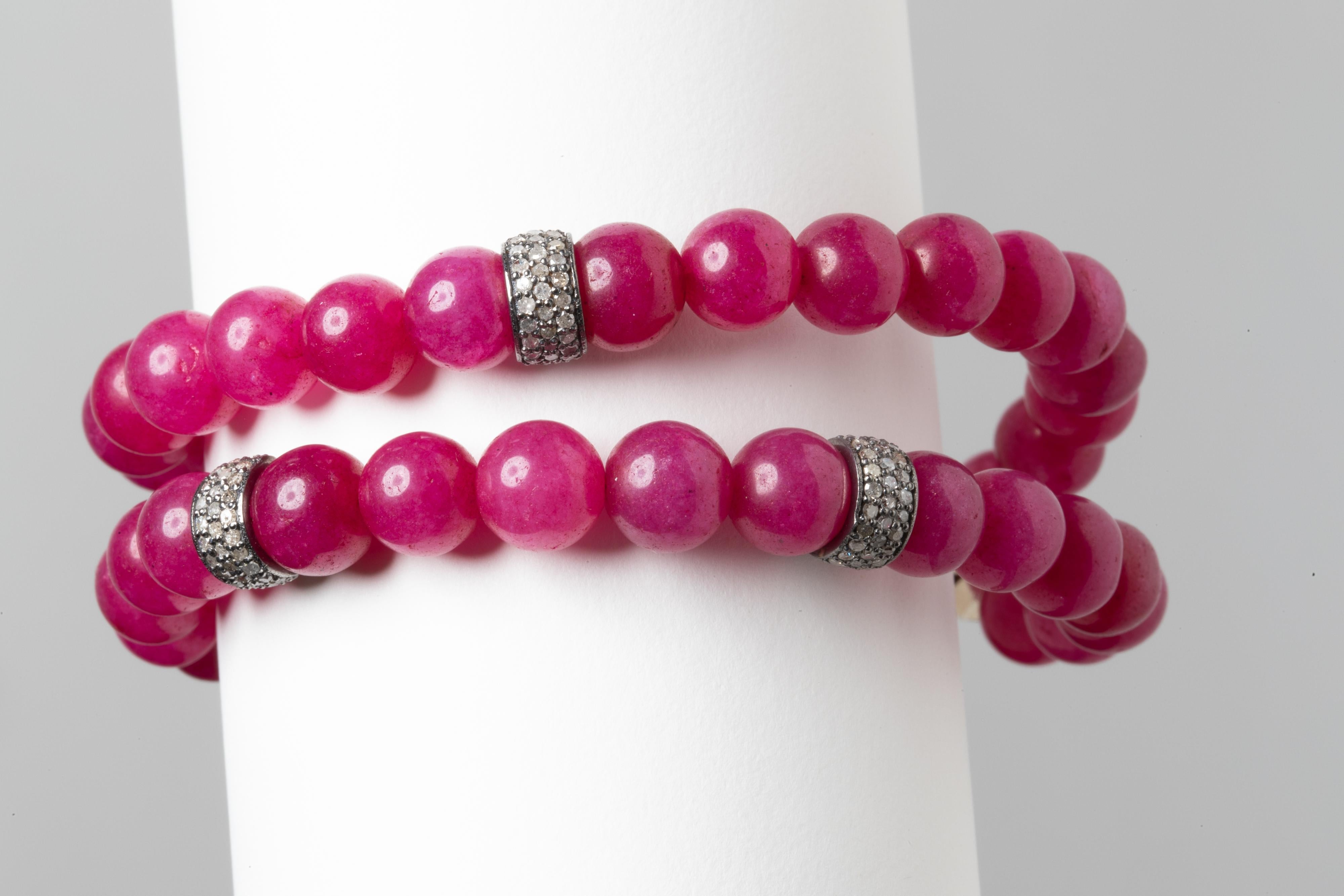 A double strand of round, 9 mm Burmese ruby beads with three pave`set diamond rondelles.  Burmese rubies are more pink than the traditional red.  An oxidized sterling silver push clasp with channel set rubies and pave` set diamonds.  By Deborah