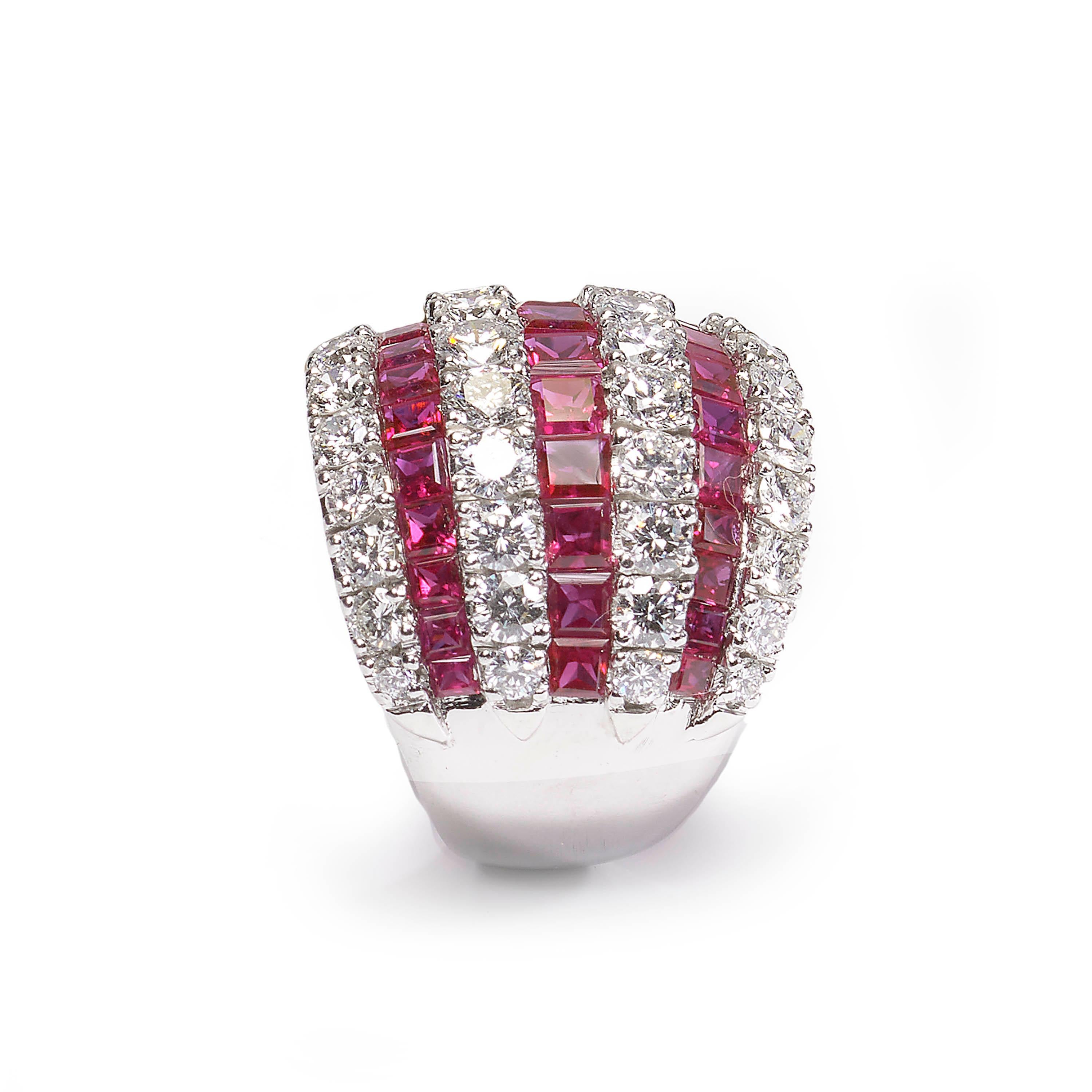 A modern bombé style ring, comprised of seven alternating rows of calibre-cut rubies and round brilliant cut diamonds, claw and channel set, mounted in 18ct white gold. Stamped 