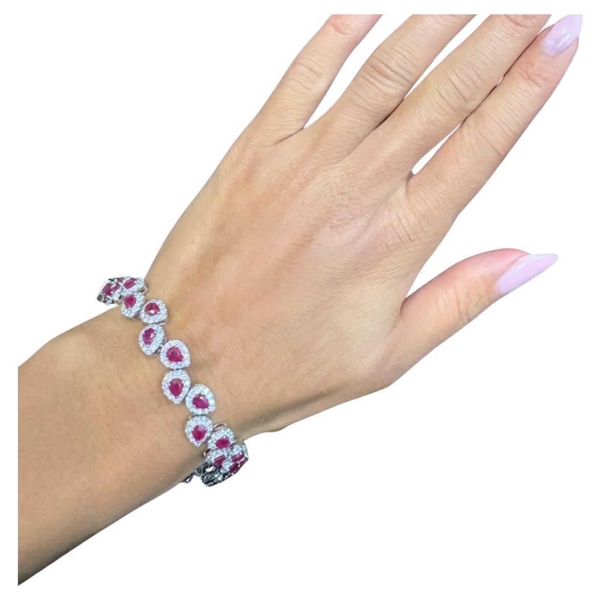 This stunning Burma ruby and diamond halo bracelet features a delicate design adorned with pear shaped Burmese rubies and round diamond halo sparkling stones, perfect for adding a touch of elegance to any outfit. Its timeless appeal makes it an
