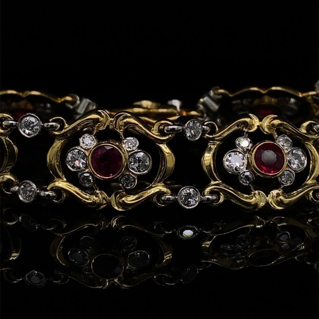 A ruby and diamond bracelet in 18 karat yellow gold and platinum, circa 1910.

This striking and unusual bracelet is designed as a series of softly curved yellow gold sections, each centrally set with a bright and lively round cut ruby which is