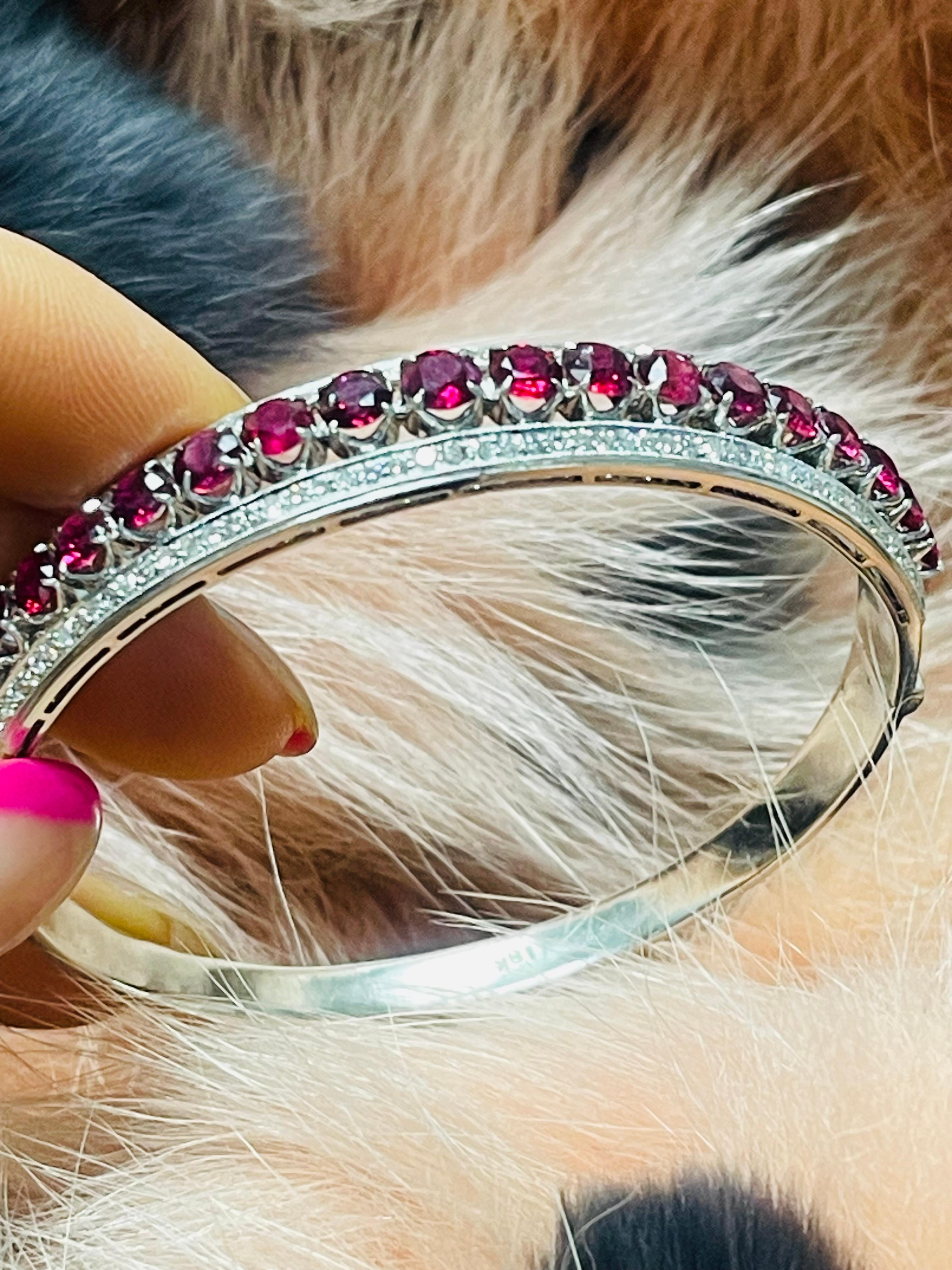 Gorgeous ruby and diamond bangle beautifully handcrafted in 18k white gold. 

The details are as follows : 

Ruby weight : 5.70 carats  ( 19 rubies) 
Diamond weight : 1.10 carats ( G color and VS clarity ) 
Gold weight : 25.14 grams 
Metal : 18k