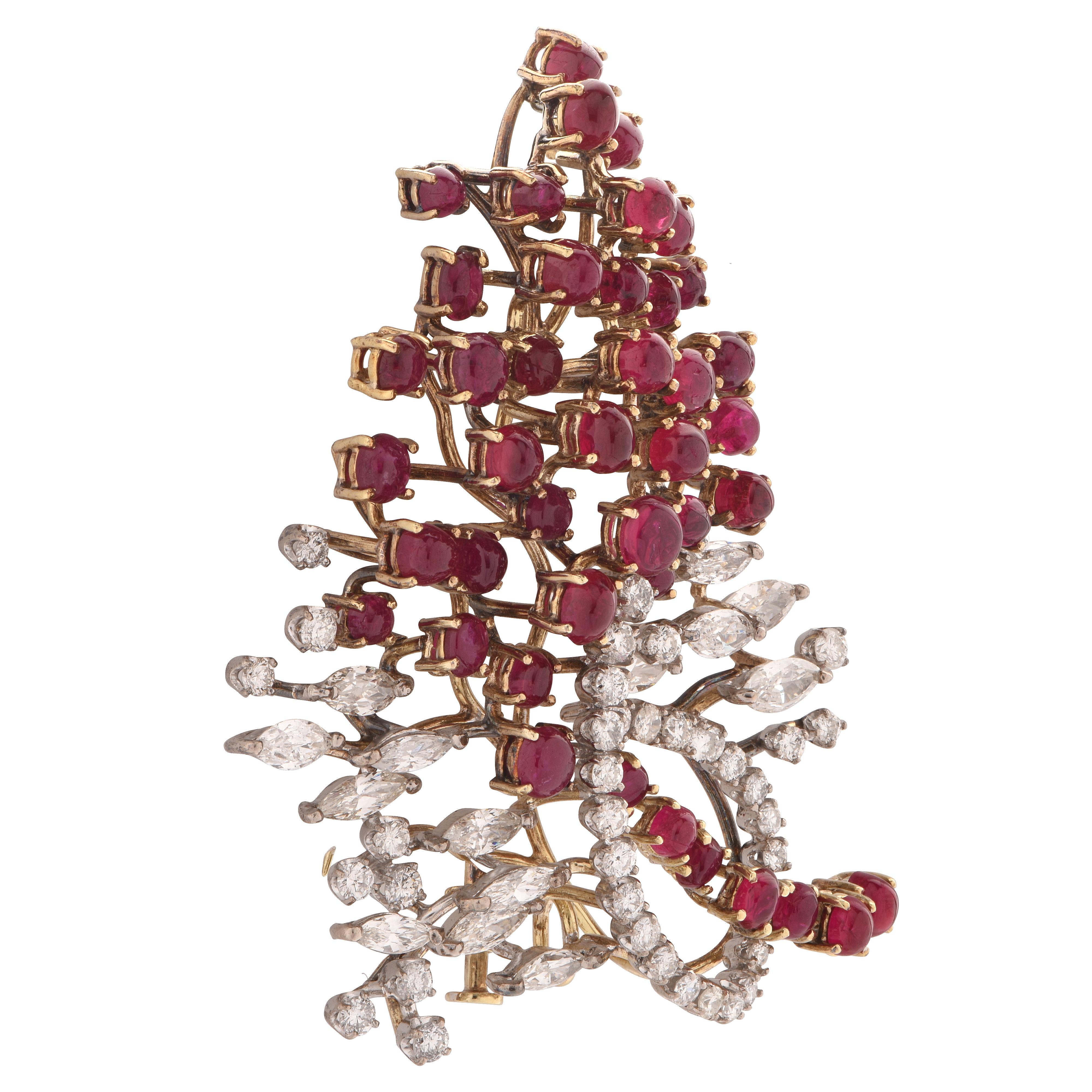 Delightful brooch pin crafted in white and yellow gold, featuring 50 round brilliant cut and marquise cut diamonds weighing approximately 5 carats total G-I color VS-SI clarity, accented by 43 cabochon cut rubies weighing approximately 6 carats