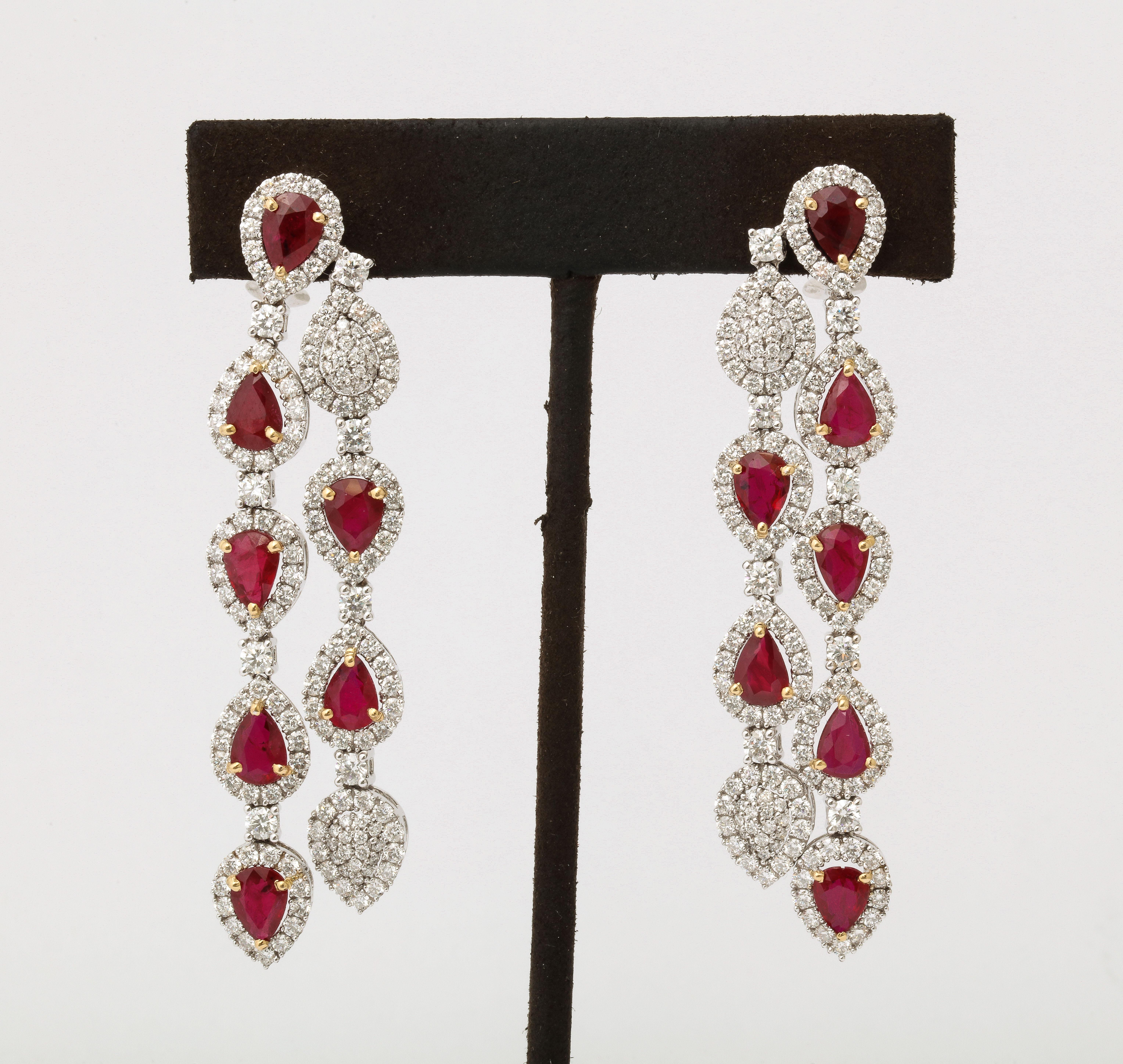 
10.15 carats of Fine Pear shape Ruby. 

7.09 carats of white round brilliant cut Diamonds. 

18k white gold 

2.6 inches long, 0.60 inches wide, approximately. 

A beautiful earring with fantastic movement and a pop of color! 