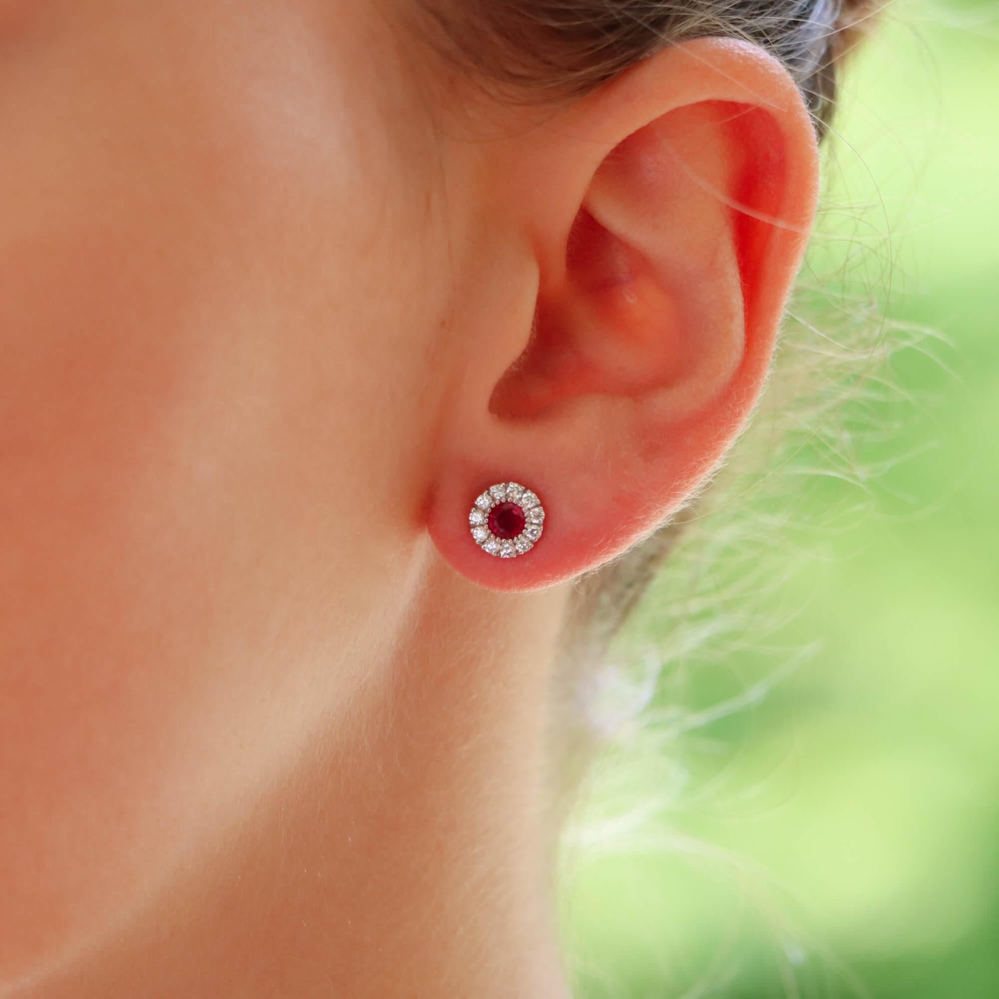  A beautiful pair of ruby and diamond cluster earrings set in 18k white gold.

Each earring is predominantly set with a vibrant round cut ruby which is millegrain set to centre. Each ruby is then elegantly surrounded by a cluster of 11 round