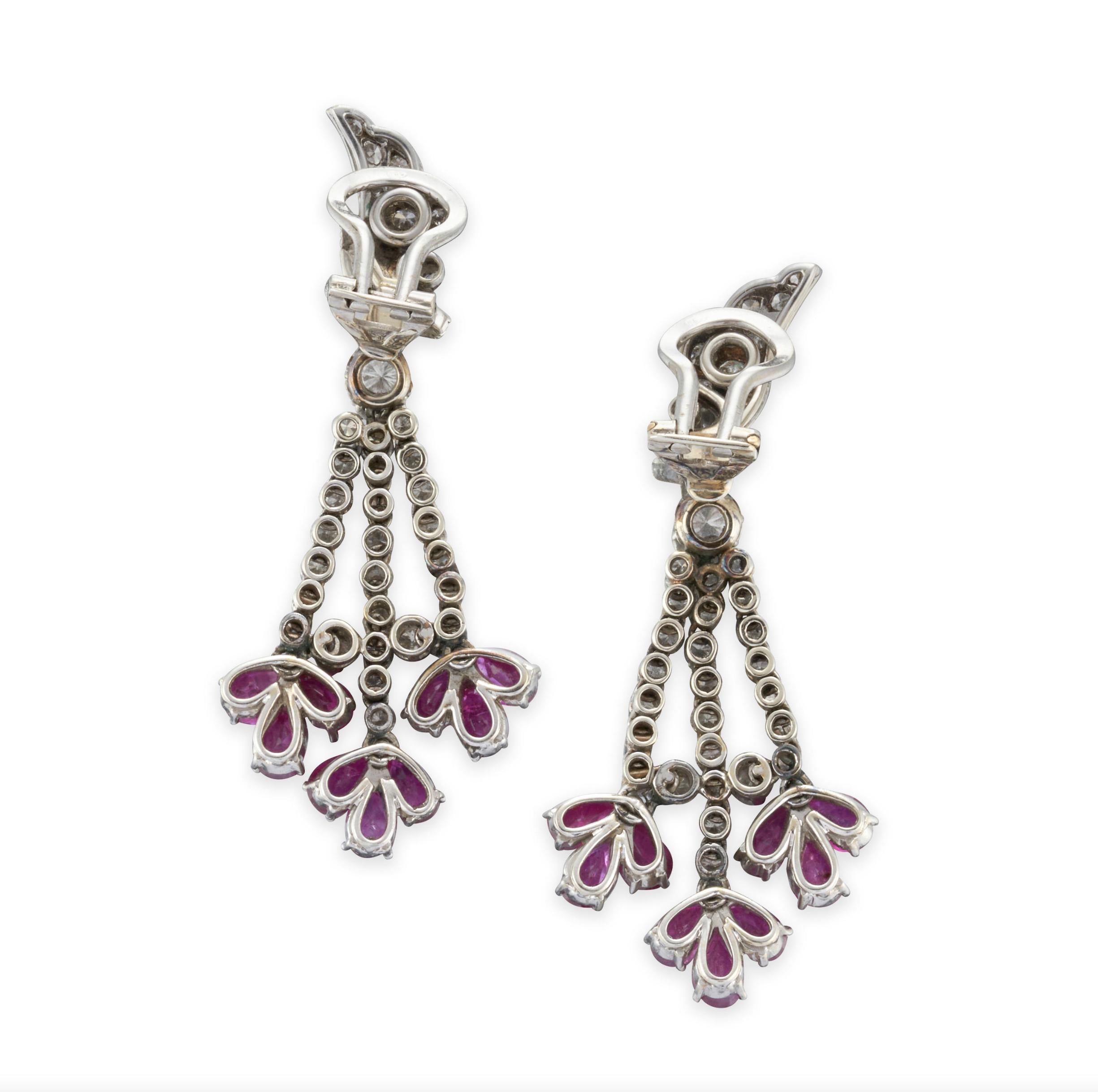 Ruby and Diamond Clip-on Earrings

Details:
Suspending articulated drops set with full-cut diamonds, approx. total weight 1.75 carats, and fancy-cut rubies mounted in 18k white gold.
Length: 2inch
Total weight of the pair: 16.8 grams

In excellent