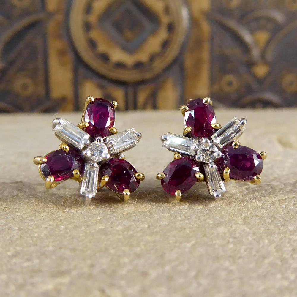These contemporary earrings each feature three oval cut rubies surrounding three baguette diamonds all around a central round cut diamond.
Modeled in 18ct white and yellow gold, they are mesmerizing on the ear!

Condition: Very Good, slightest signs