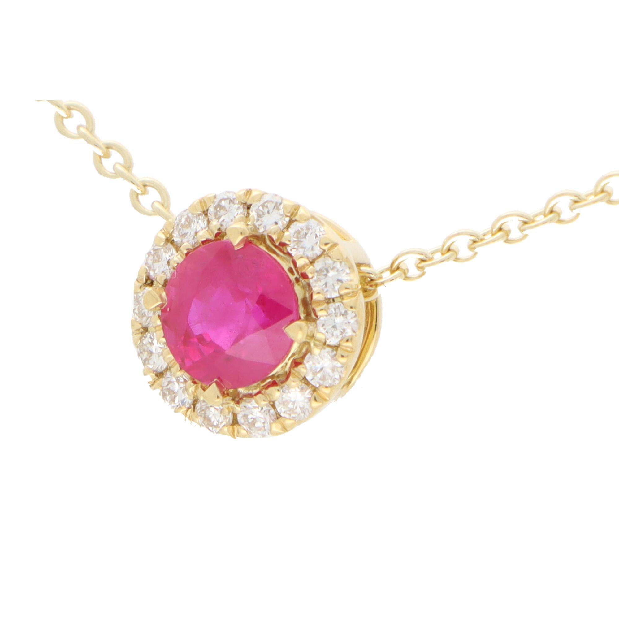 A beautiful ruby and diamond cluster pendant set in 18k yellow gold.

The pendant is centrally set with a vibrant pinkish-red coloured round cut ruby which is surrounded by 14 sparkly round brilliant cut diamonds. The pendant hangs from a 9k yellow