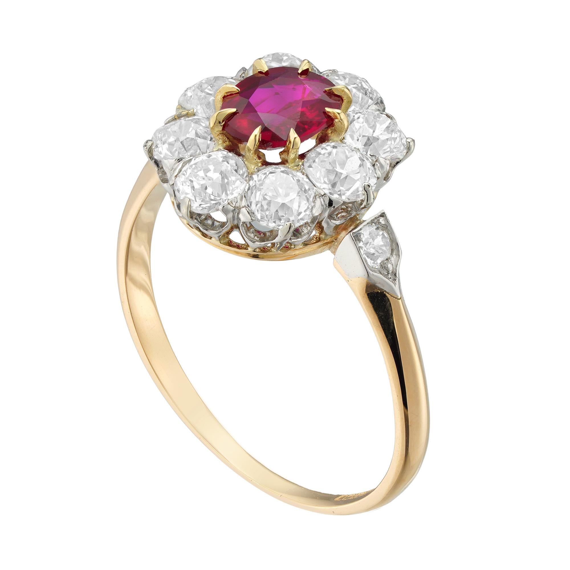 A ruby and diamond cluster ring, the oval faceted ruby estimated to weigh 0.65 carats, surrounded by eight old brilliant-cut diamonds estimated to weigh 1.35 carats in total, all claw set in a white to yellow gold mount with diamond set