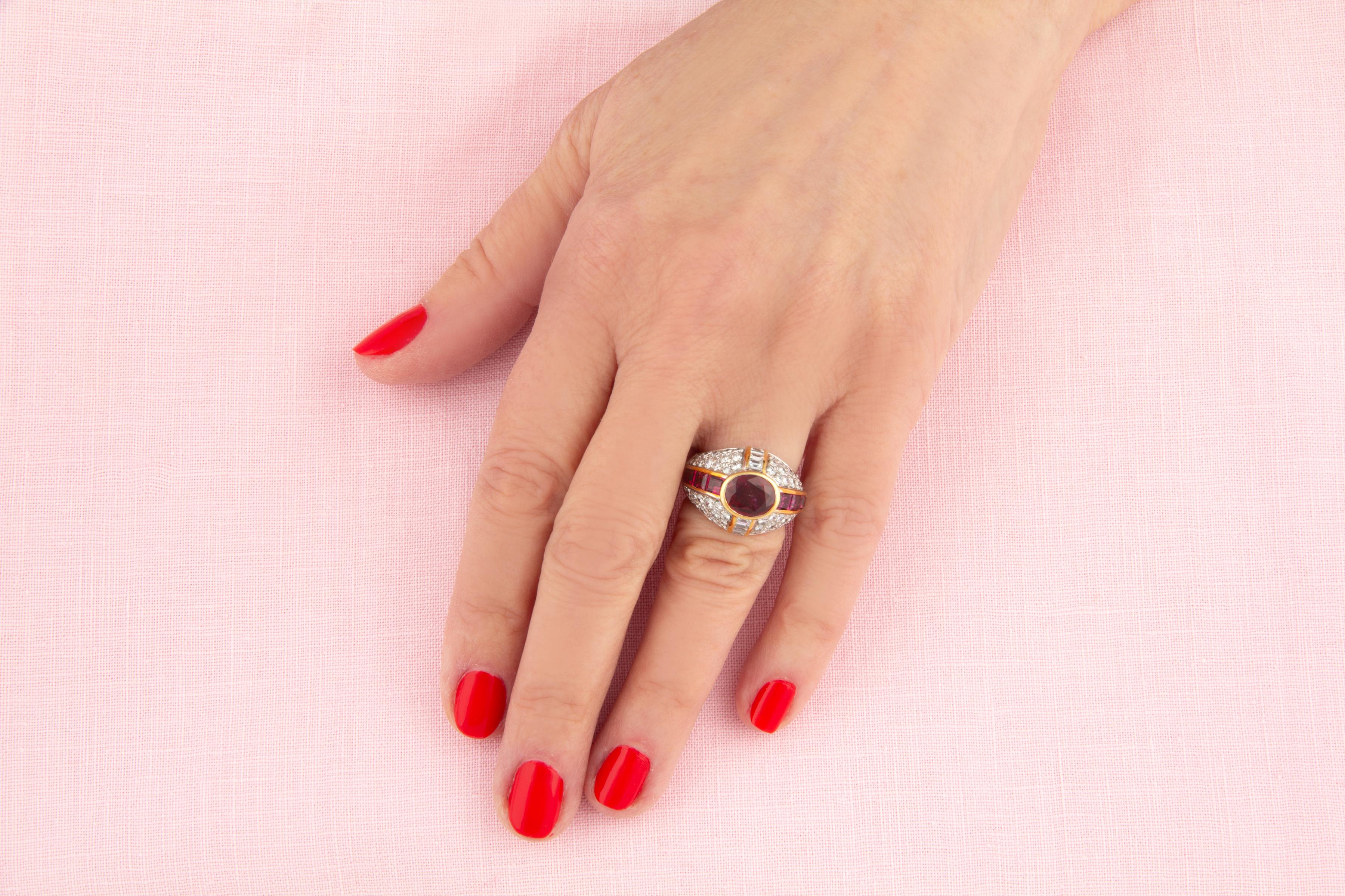 Der Cocktailring mit Rubin und Diamant enthält einen oval geschliffenen, facettierten Rubin von brillanter Farbe mit einem Gewicht von 2,25 Karat. Der Ursprung des Rubins ist Thailand. Der Mittelstein wird von speziell geschliffenen, kanalgefassten