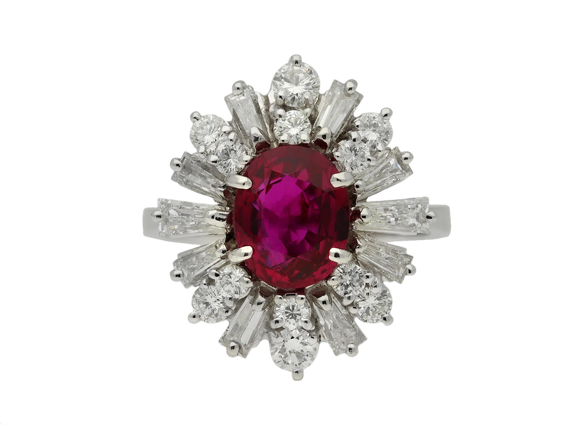 Ruby and diamond coronet cluster ring. Set with an oval old cut natural unenhanced Siam ruby in an open back four claw setting with an approximate weight of 2.00 carats, encircled by two stepped rows of round brilliant cut diamonds in open back claw
