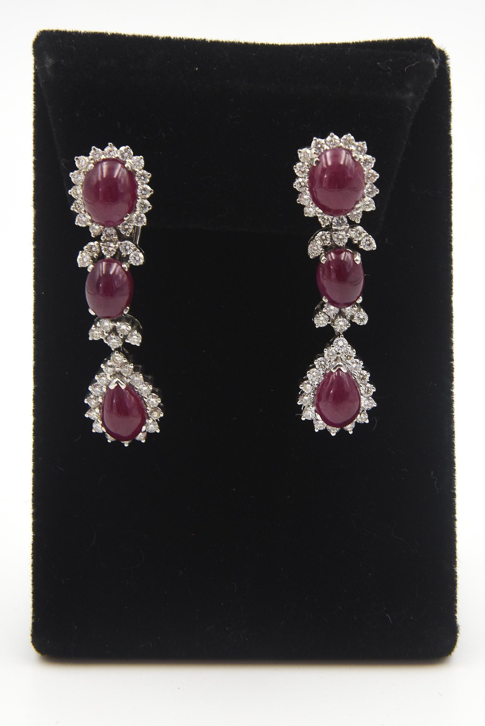 Eleganti orecchini pendenti con rubini e diamanti, con 3 rubini cabochon in ciascun orecchino e diamanti rotondi.  La sezione inferiore balla da destra a sinistra quando viene mossa.  Gli orecchini sono in oro bianco 18 carati con 2,61 carati di