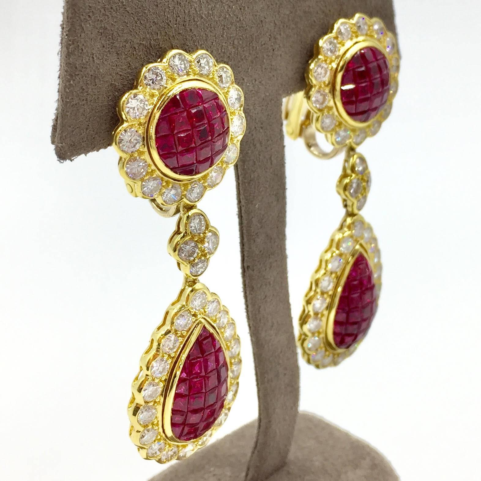 A true statement drop earring set in 18K yellow gold. Pear shaped design drop. Vivid rubies are beautifully invisibly set. Diamonds are of very nice color and clarity - approximately G color, VS2 clarity. Exceptional craftsmanship with an intricate
