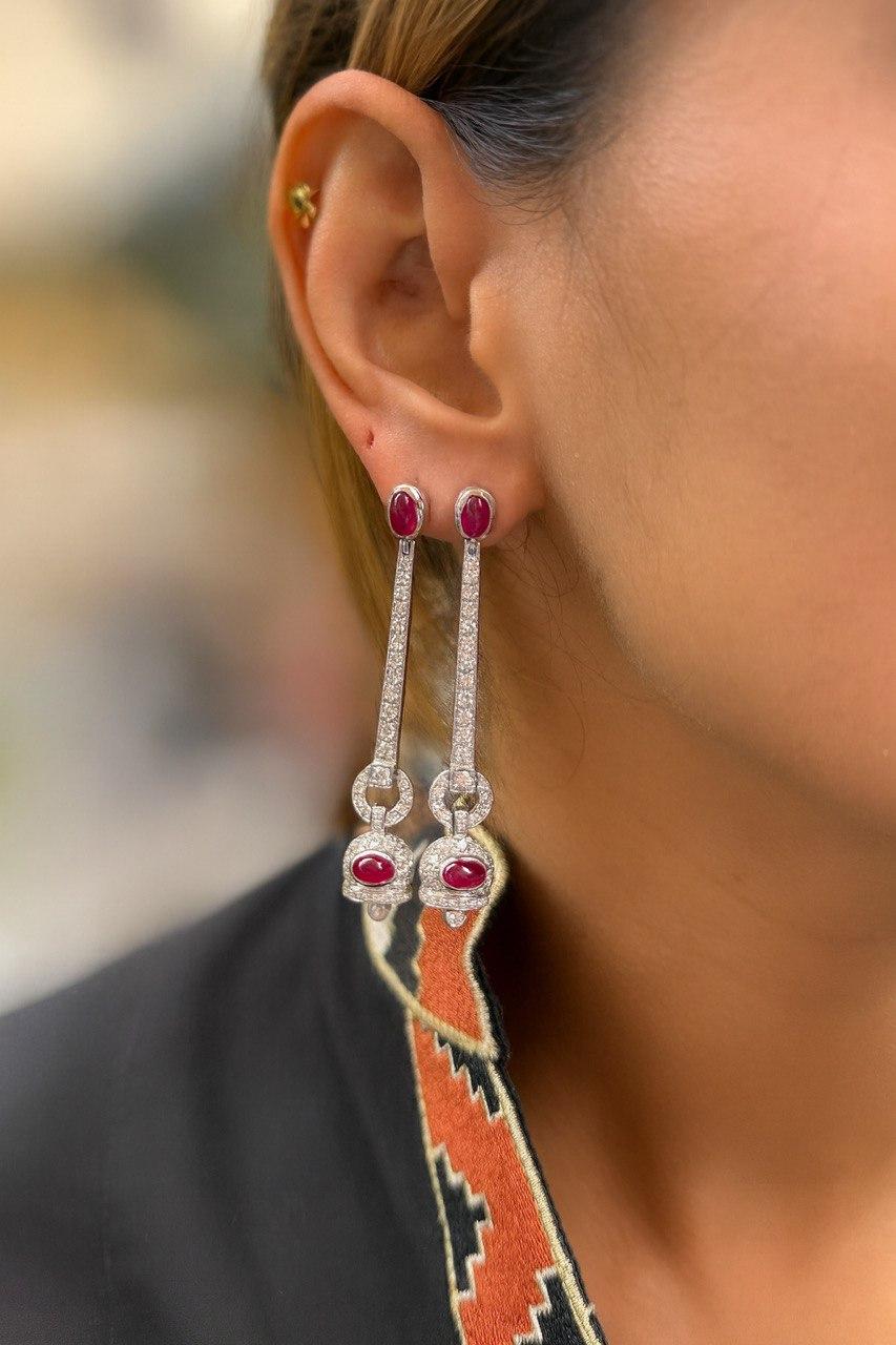 PAIR OF CALIBRATED RUBY DROPS
They feature a oval motif set with calibrated rubies, a central Ruby, held by an articulated line set with brilliant-cut diamonds. 18K white gold setting.
Gross weight: 14.9 gr
Diamond weight: approximately 2.80