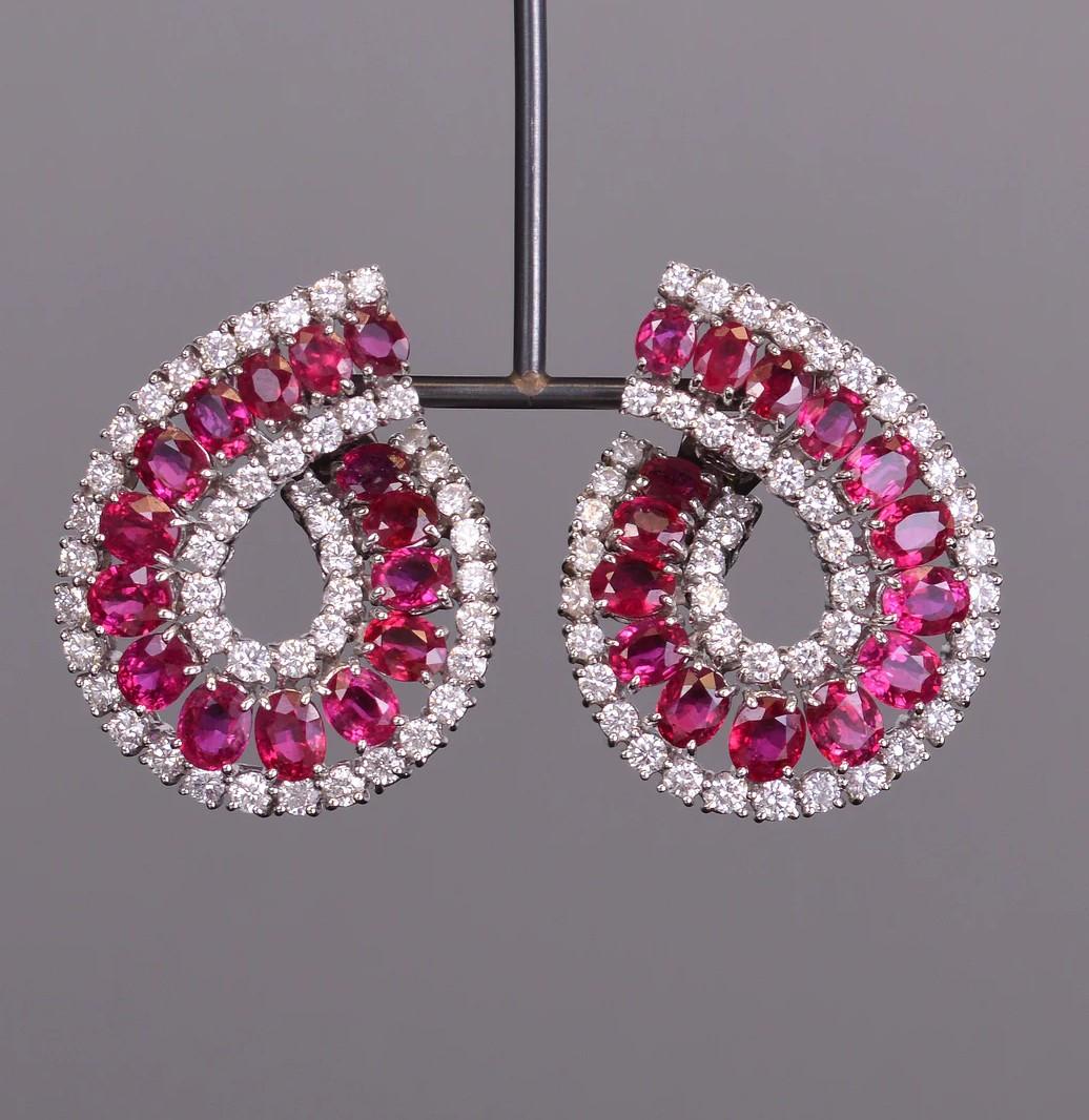 Questi orecchini brillano come nessun altro! Sono realizzati con 15,25 carati di splendidi rubini e 5,39 carati di scintillanti diamanti bianchi, tutti incastonati con gusto in oro bianco 18 carati. 35,5 mm x 27,2 mm