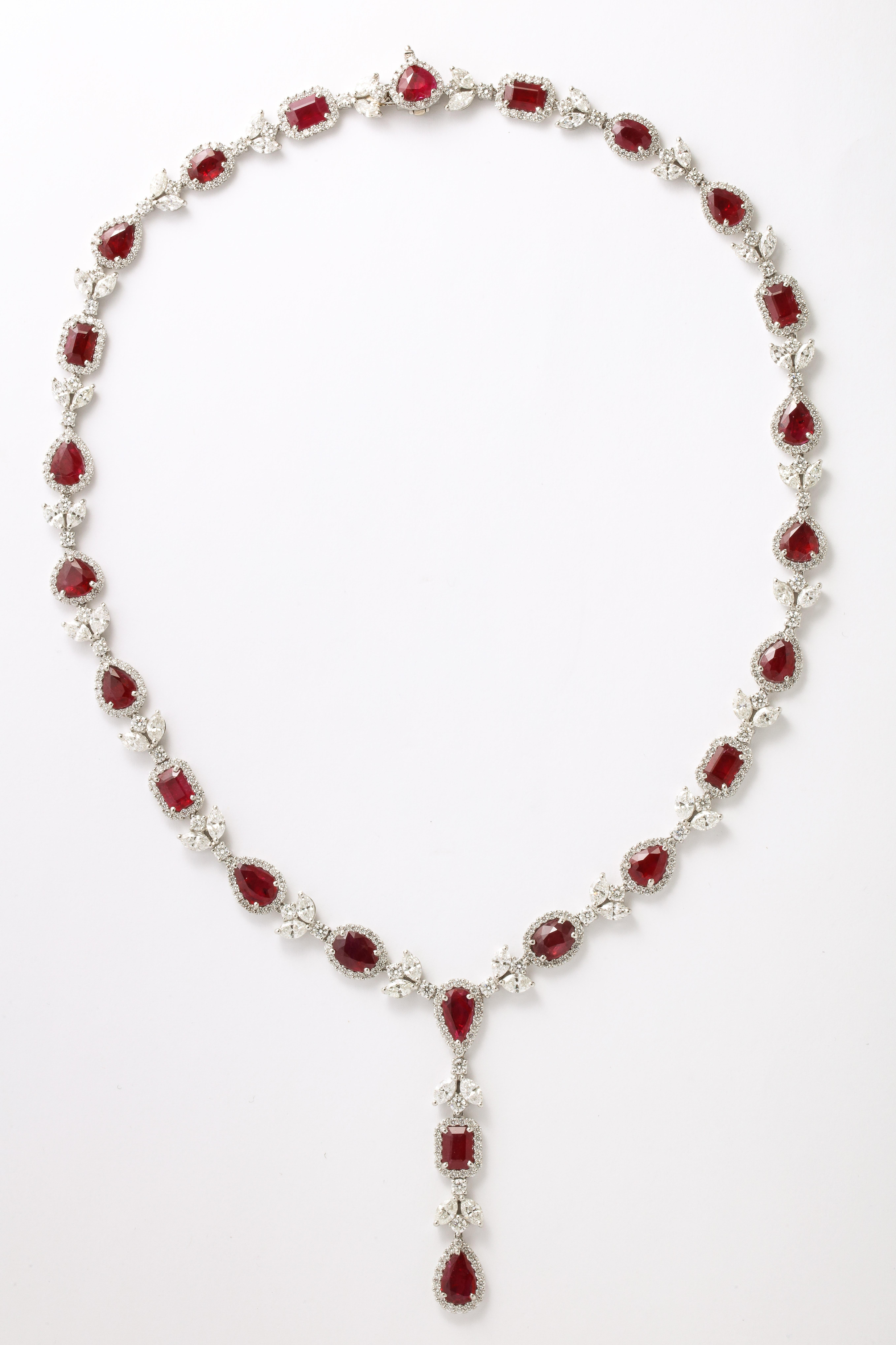 
A Stunning Multishape Ruby and Diamond Necklace. 

28.36 carats of pear, oval, emerald cut and heart shaped Ruby. 

19.12 carats of white marquise and round brilliant cut diamonds. 

Set in platinum. 

17 inch length with an approximate 2 inch drop