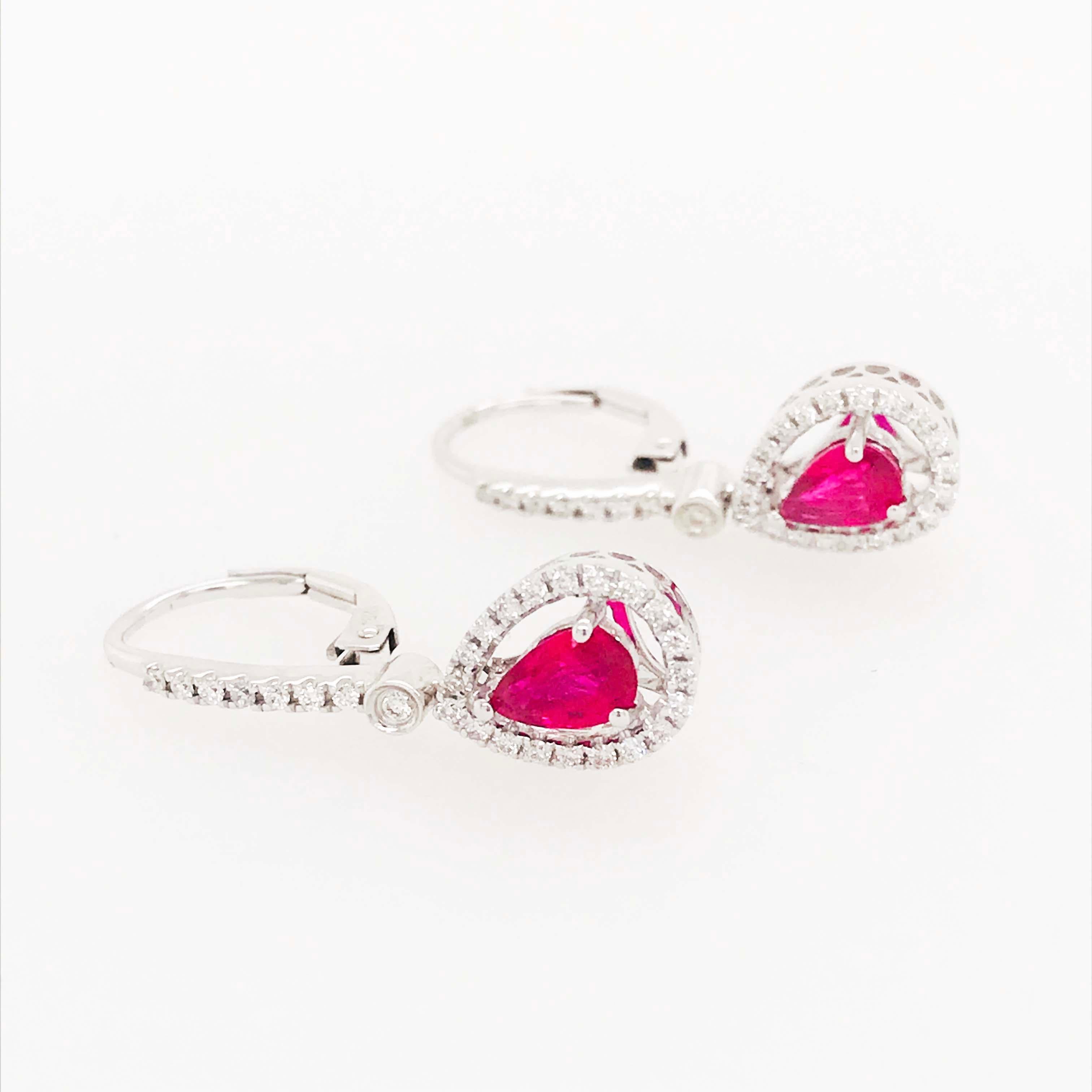 Diese Ohrringe mit echten Rubinen und Diamanten sind atemberaubend! Am unteren Ende jedes Ohrrings ist ein birnenförmiger Rubin gefasst, umrahmt von einem diamantenen Halo, der funkelt und den Rubin wunderschön zur Geltung bringt. Die rubinroten