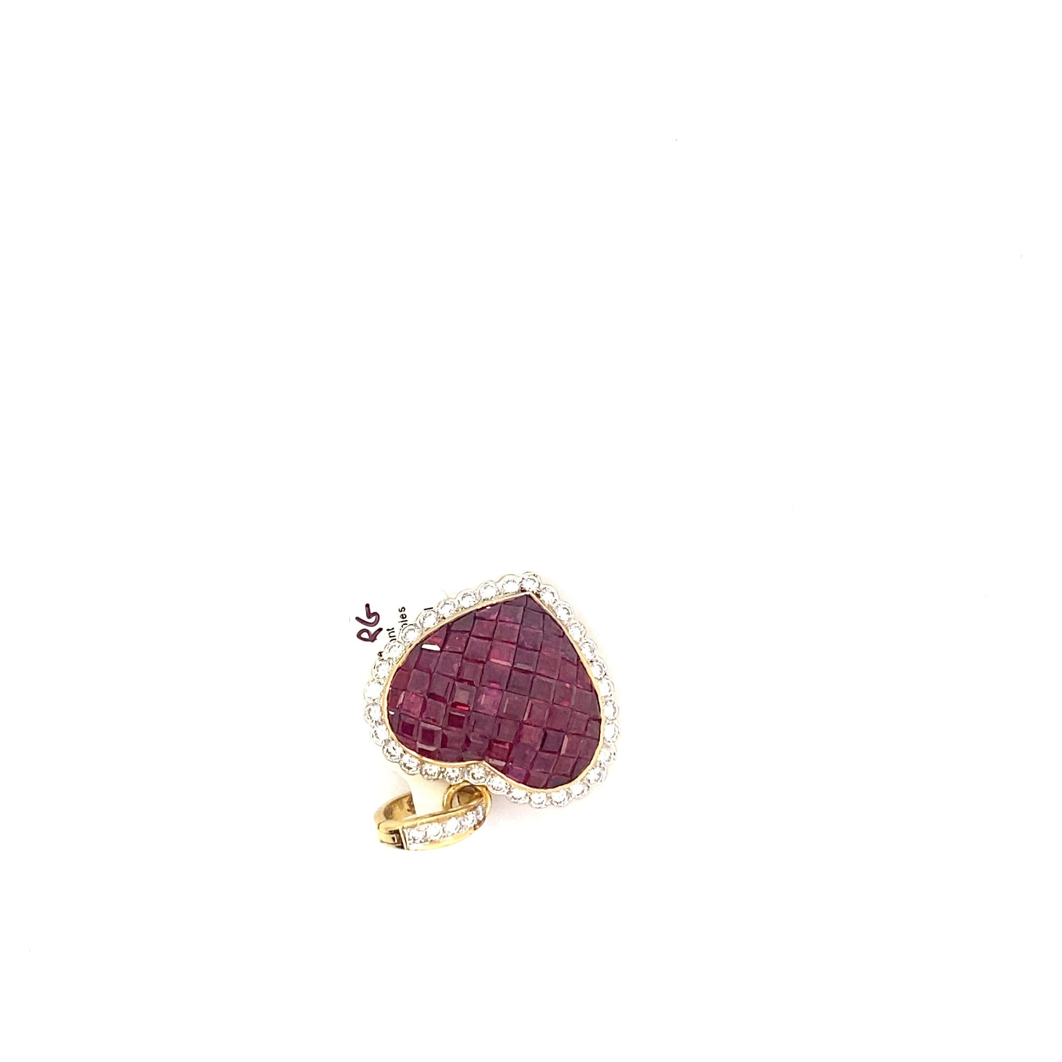 Ce magnifique et lourd pendentif vintage présente des dizaines de rubis taillés en escalier qui forment le cœur. Ces rubis sont d'une couleur délicieusement foncée avec une nuance violette profonde. La mosaïque luxueuse de rubis est encadrée d'une