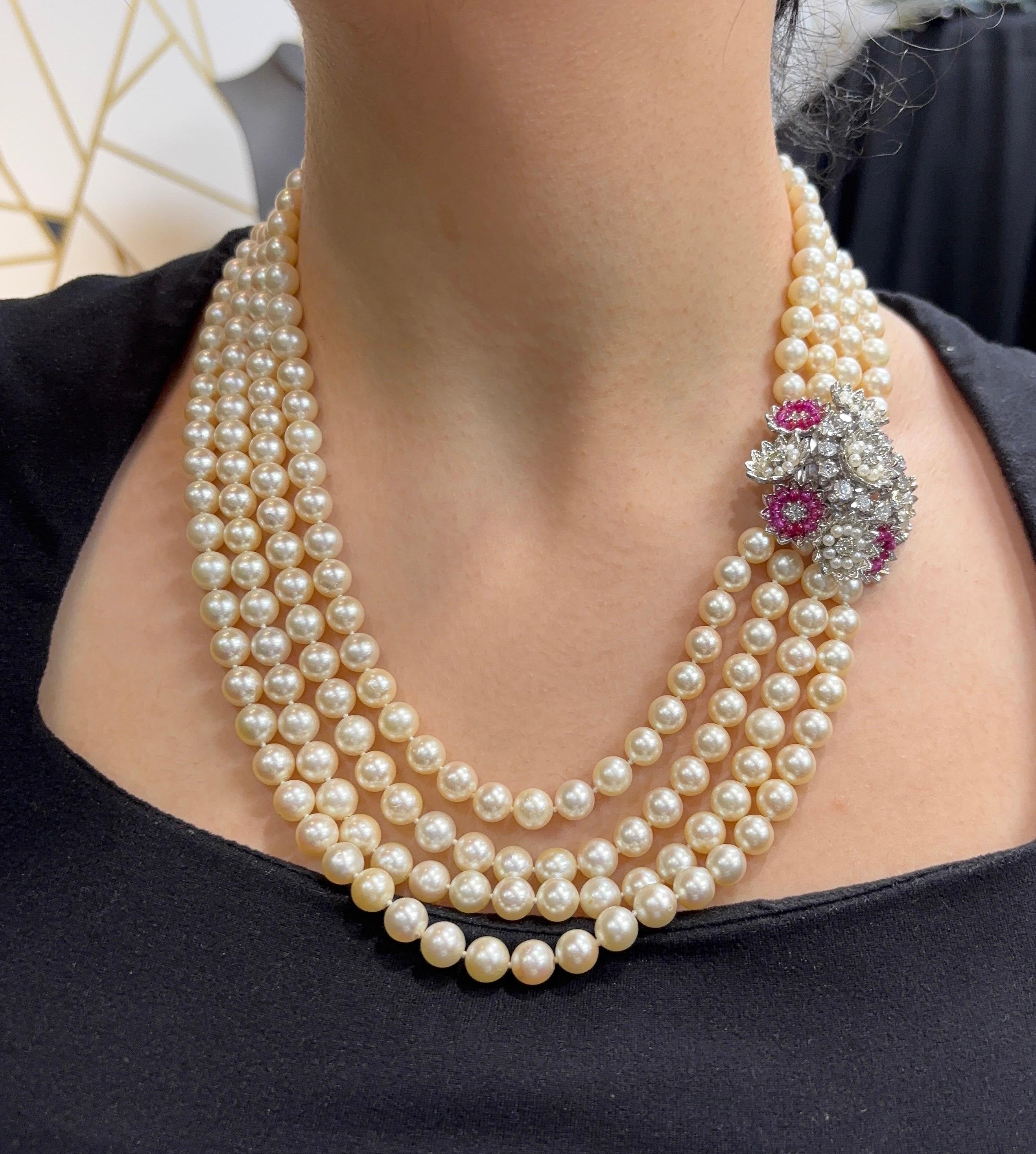 Collana con ciondolo a quattro fili di perle.

Una collana con quattro fili di perle coltivate e una chiusura con diamanti, rubini e perle a motivo floreale. 

Misure: 20