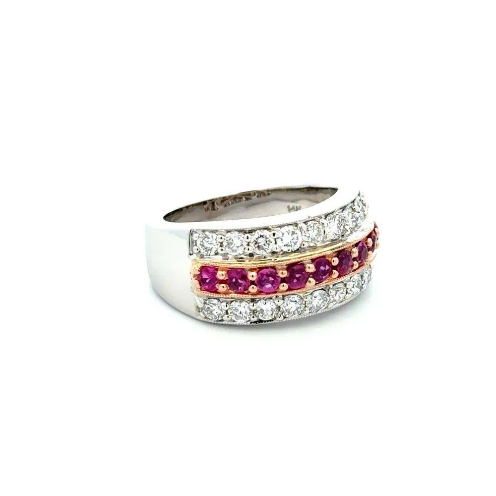 Simply Beautiful! Ruby and RBC Gold 10.25mm Band Ring. Centering securely Hand set 9 Fine High Quality Round Rubies, weighing approx. 1.35tcw, surrounded by Round Brilliant Cut Diamonds, weighing approx. 1.65tcw. Hand crafted 14K White Gold