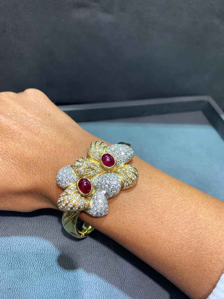 Ruby And Diamond Gold Flower Fancy Bangle Bracelet
 2 Cabochon Rubies approx 6 ct
Approx Diamond Weight: 9.50 Cts
Wrist Size/inner diameter: 2.25