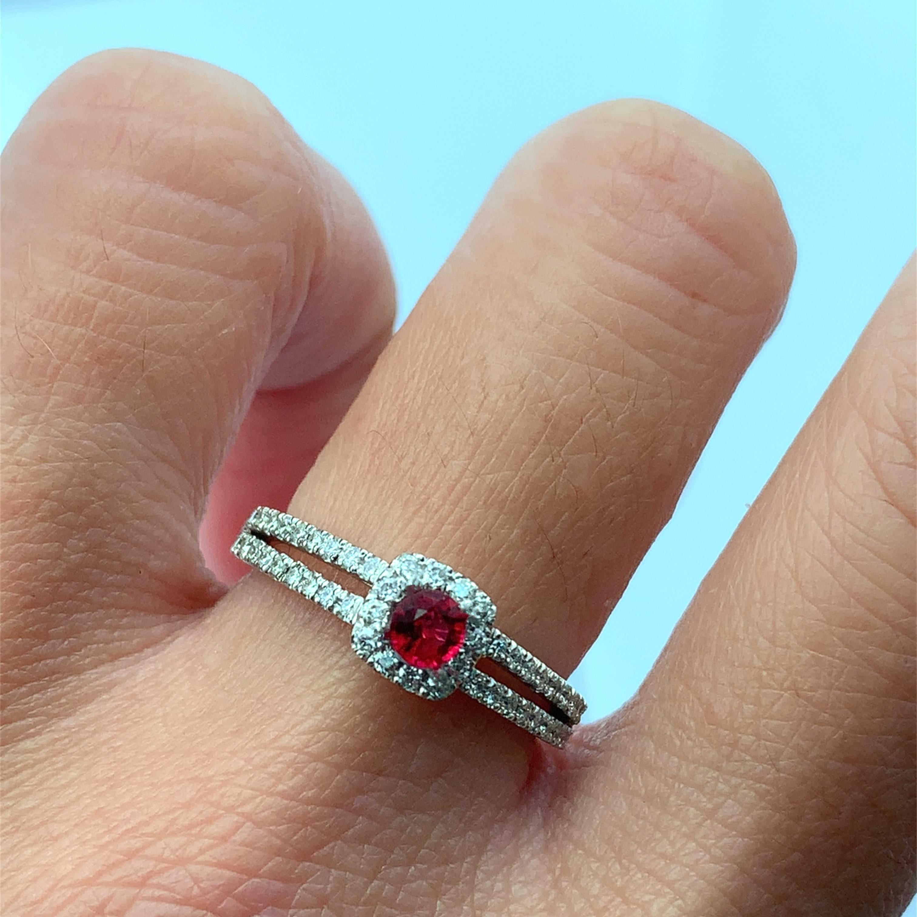 Discover the timeless beauty of this elegant Ruby and diamond ring. Featuring a stunning central red round cut Ruby gemstone surrounded by a halo of sparkling diamonds, this piece is perfect for engagements or special occasions. Its intricate design