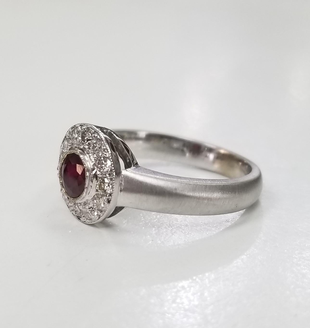 14k white gold ruby and diamond ring, containing 1 round cut ruby of fine quality weighing .33pts. and 12 round full cut diamonds of very fine quality weighing .35pts. set in a halo with a fiberglass finish on the shank.  This ring is a size 7 but