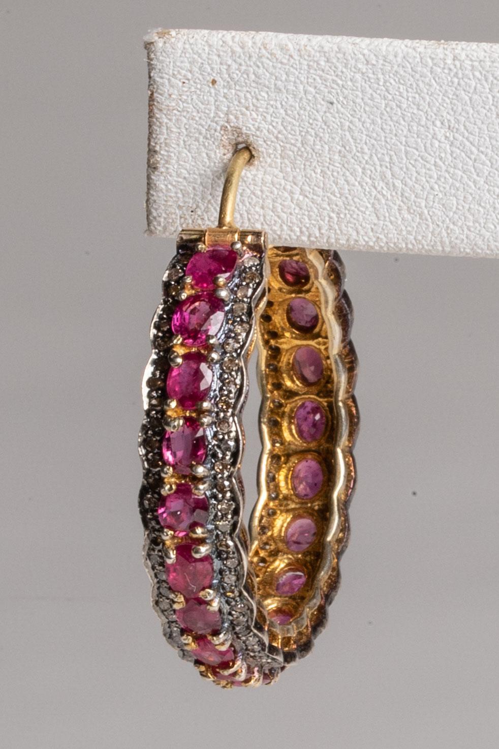 Faceted round rubies in a bezel setting bordered by round, brilliant cut diamonds in a pave` setting.  The stones run all the way around the hoop from the front to the back and set in vermeil (gold over sterling).  The post is is 18K gold for