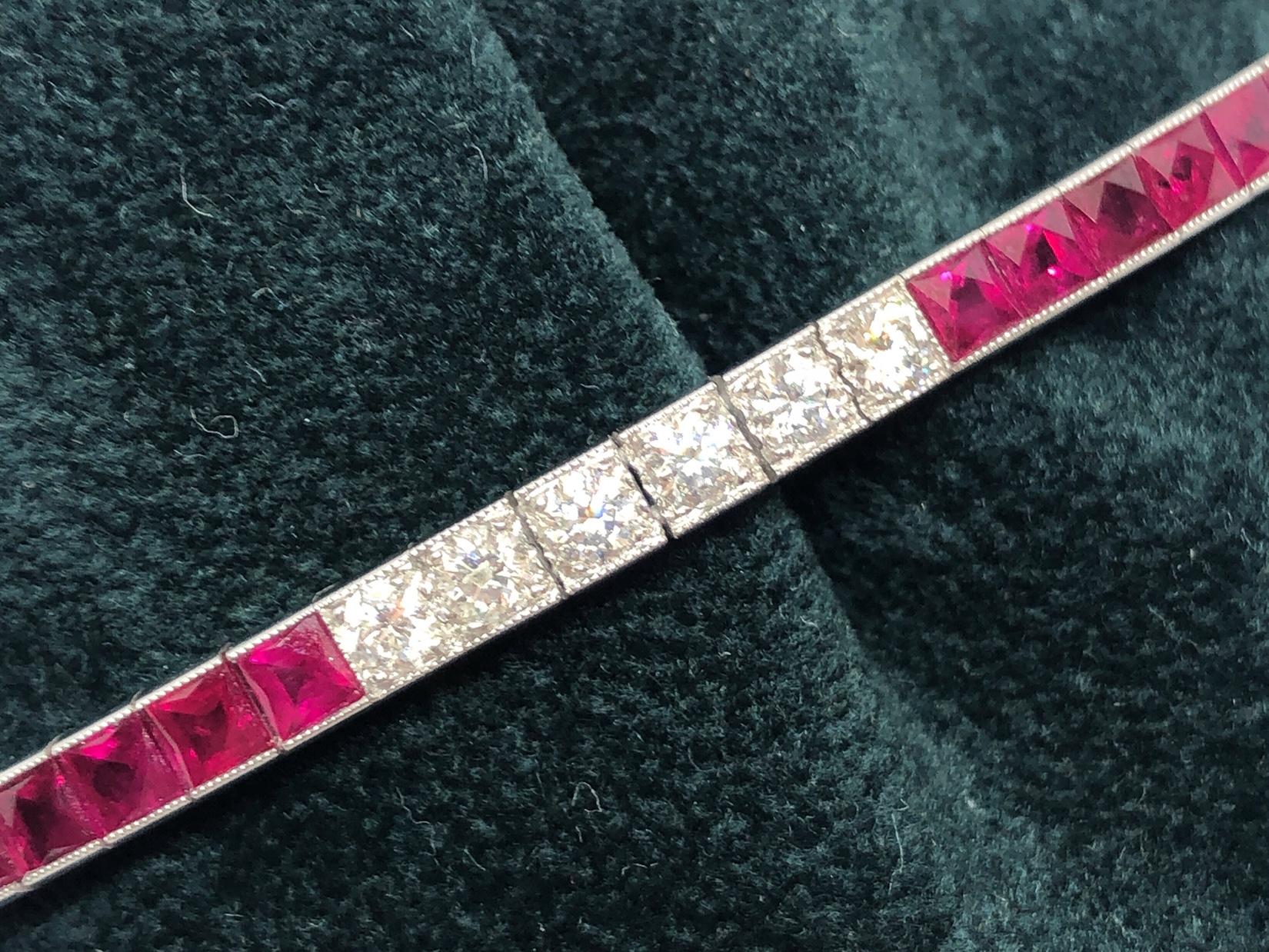 A ruby and diamond line bracelet set with 28, round brilliant-cut diamonds, with a total weight of 1.215ct and 33, French-cut rubies, with a total weight of 6.22ct, mounted in 18ct white gold, with milegrain edge settings and foliate engraved sides.