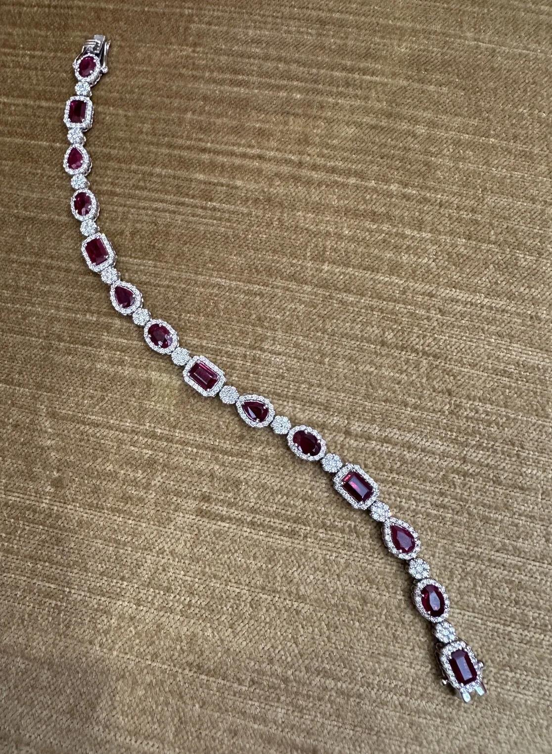 Bracelet à maillons en or blanc 18 carats avec rubis et diamants d'un poids total de 7,65 carats

Le bracelet de diamants et de rubis comprend 14 rubis naturels de taille émeraude, ovale et poire sertis de halos de diamants ronds avec des fleurons