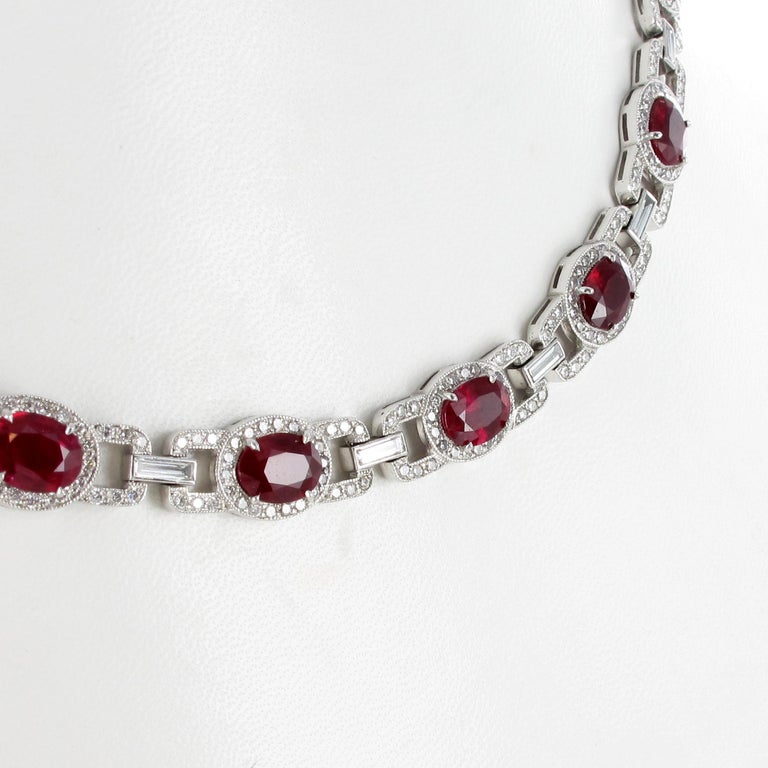 This beautifully elegant necklace in platinum 950 features 22 oval-cut rubies from Burma. They are of pure and intense red colour and have a total weight of approximately 22.00 carats. Each ruby is surrounded by brilliant-cut diamonds of G/H colour