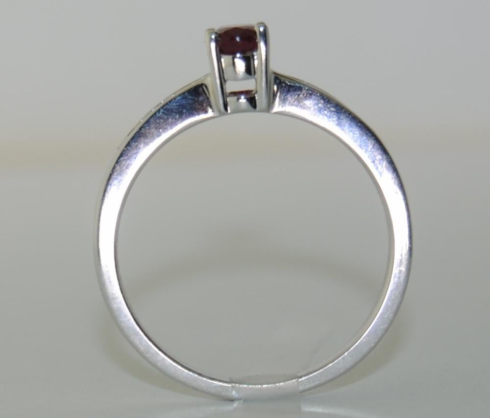 This 14 karat White Gold Ring has 1 Oval Cut and 4 Princess Cut Ruby that weighs .79 carats , with 4 Princess Cut White Diamond that weighs .19 carats.  
Ring size: 7